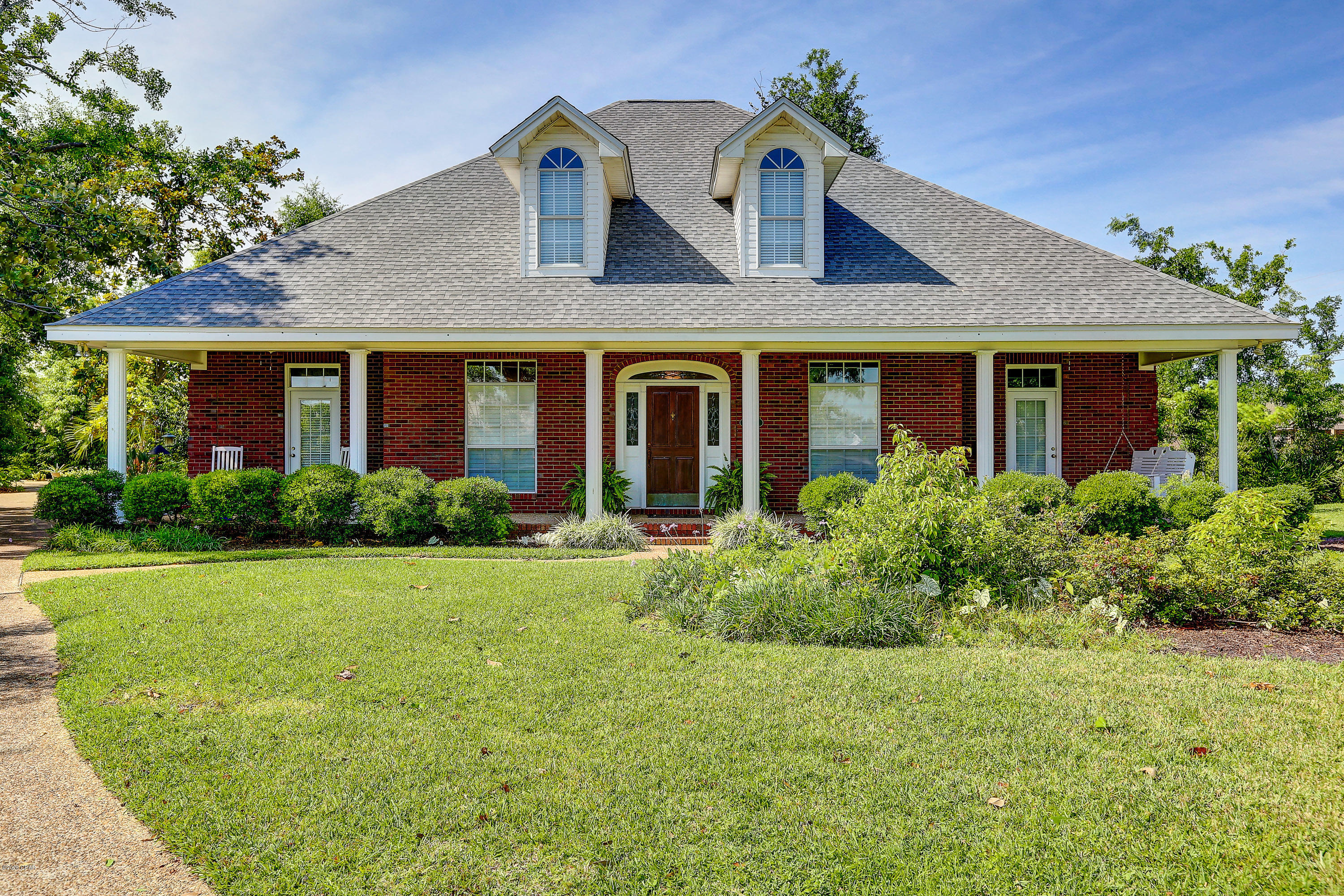 Exquisite home in the Panama Country Club. This custom home features hard wood floors in the foyer and formal dining room, 10' ceilings, & new whole-home generator.  The large eat-in kitchen has a new gas stove, plenty of cabinet space, and a large bay window in the breakfast nook.  Just off the kitchen is  the laundry room , half bath, and access to the 3-car garage.  The living room includes a gas fireplace, built-in bookcases, and 2 sets of French doors that lead to the back patio. Home also has a gas hot water heater & gas furnace.

The exterior of this home includes a grand front porch, new fence, extra large yard area, back patio, and 3-car garage with extra storage space. Home can be accessed from Country Club Court, Country Club Drive, and Colorado Ave.
