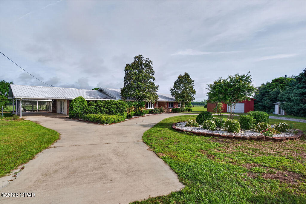Spacious brick home on acreage in the desirable Orange Hill area, conveniently located just a few miles from town! This well-maintained property offers spacious rooms, updated windows, crown molding throughout, tile and luxury vinyl plank flooring, landscaped flower beds, fruit trees, and multiple outdoor features to enjoy. A circular drive welcomes you to the home, with a covered front porch just off the parking area, attached carport, and a detached garage installed in 2025 with garage doors on each side and garage door openers. The property also includes a large 108' x 38' barn, covered koi pond, open patio, and sunroom. Inside, you'll find a formal dining room and spacious kitchen with granite countertops, breakfast nook, and bar seating. The primary ensuite features a tiled stand-up shower, two walk-in closets, and installed grab bars in the shower and along bath walls for added safety and support. A large family room offers flexible use and could serve as a second master bedroom, creating a split floor plan. This room includes two walk-in closets, French doors leading to the carport, and a half bath nearby off the mudroom. The acreage is partially fenced with neighboring fences along portions of the property, offering potential to add front fencing for a more enclosed setup for animals. With generous indoor living space, excellent storage, outdoor amenities, and a sought-after Orange Hill location, this property is a must-see!