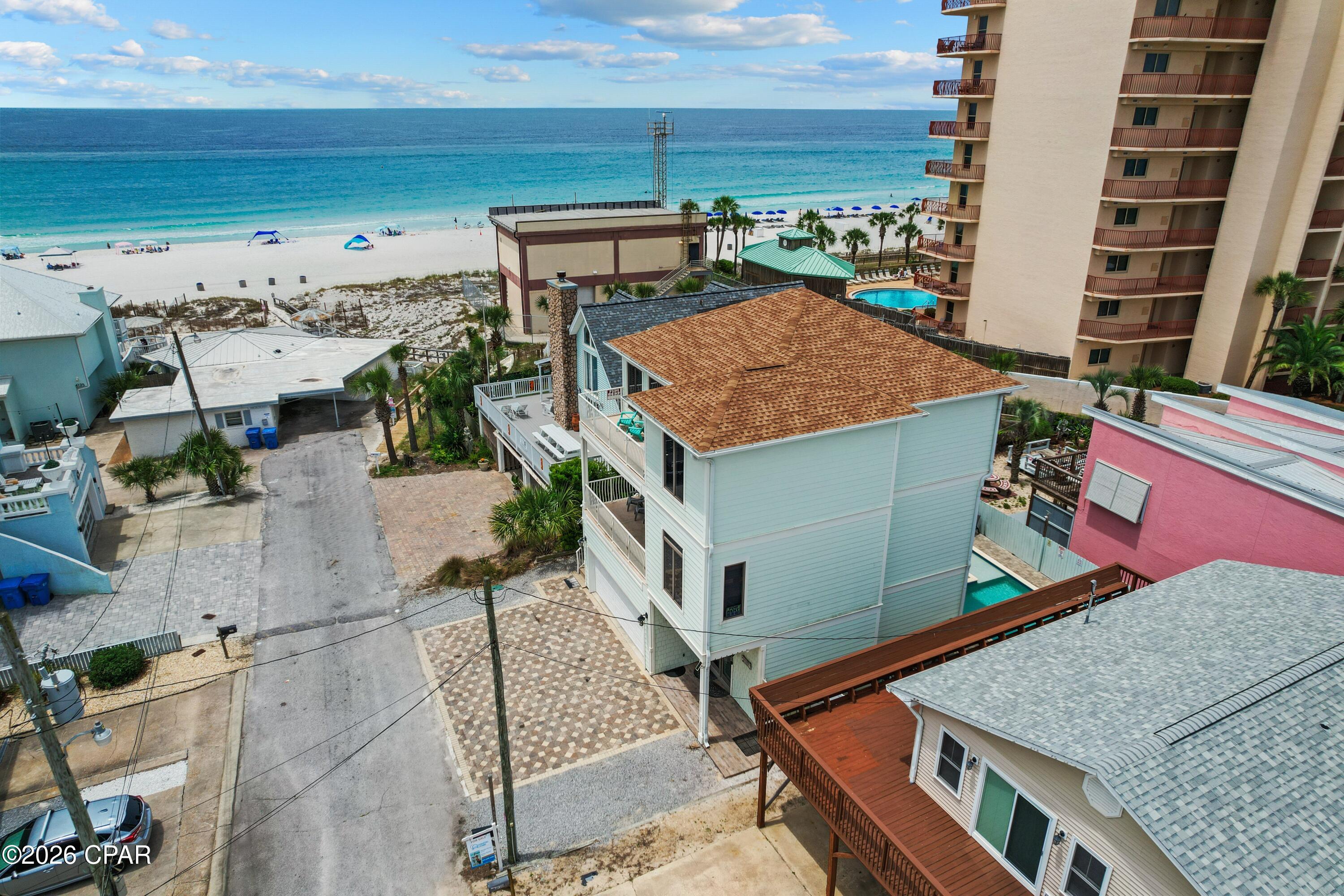 EXCEPTIONAL VALUE ALERT - PRICE IMPROVEMENT OF $150,000! Repriced for immediate sale, this elegant Mediterranean-style beach home presents an outstanding opportunity on the Emerald Coast. Located just 75 feet from the sugar white sand with Gulf views from multiple balconies, this spacious 3-story property is being offered FULLY FURNISHED and TURNKEY with  $215,000 in 2025  rental income and future bookings transferable to the new owner.

Featuring 7 bedrooms, 4 full baths, and approximately 3,451 square feet, this thoughtfully designed home offers flexibility for personal use, large groups, or vacation rental investment potential. Interior features include soaring 10-foot ceilings, custom cabinetry, granite countertops, stainless steel appliances, commercial-grade tile flooring, and abundant natural light throughout.

Designed with functionality in mind, the property includes TWO full kitchens, TWO laundry areas, and a lockout configuration ideal for maximizing occupancy and rental versatility. Spacious indoor and outdoor living areas provide ample room for entertaining and relaxing after a day at the beach.
Outdoor highlights include a PRIVATE HEATED POOL, expansive balconies with Gulf views, covered patio spaces, and ample parking with a 2-car garage plus 5 additional driveway parking spaces. Low annual HOA dues add to the appeal of this exceptional coastal property.

Whether you're searching for a primary residence, second home, or income-producing beach investment, this turnkey property offers space, location, and exceptional value in the heart of Panama City Beach.