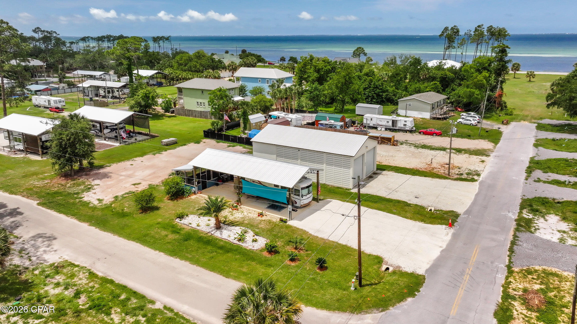 : Catch breathtaking sunset and bay water views every evening from this fully improved RV-ready property at 288 Duval St in the heart of Port St. Joe. Designed for the ultimate coastal lifestyle, this one-of-a-kind setup features a massive 19 ft at center hurricane-rated pole barn professionally built using top-of-the-line materials, offering exceptional protection and functionality for your RV, boat, and gear. The oversized 22x50 concrete RV pad easily accommodates large rigs, while an additional 20x10 concrete pad supports the enclosed screened back porch, a $15,000 upgrade that creates comfortable year-round outdoor living space. The property is fully connected to city sewer and water, and the electric line has been professionally buried for a clean, polished look. Approximately 15 loads of fill dirt were brought in to properly elevate and grade the property, while pellet gravel throughout provides low-maintenance accessibility and durability. The lot has two separate electrical hookups- one in the back with 50 and 30amp options and an additional 120V 30 amp hookup at the driveway allows a second RV or guest camper to plug in with ease. Palm trees and professional landscaping complete the tropical coastal feel and beautifully frame the property's incredible water and sunset views. Whether you are a full-time RVer, weekend adventurer, or seasonal coastal traveler, this turn-key property is ready for immediate enjoyment -- just bring your rig and start living the Forgotten Coast lifestyle.