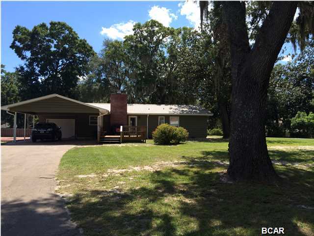 This wonderful home has been completely renovated within the last three years. Plumbing and electrical is new, kitchen and bathrooms have been redone, and gorgeous original hardwood floors have been restored. There is a gas fireplace in greatroom/dining area, new light fixtures throughout home. Kitchen has new appliances, home has tankless water feature. Some of the best features is this large lovely lot with big oak trees, across the street from the lake. The outdoors features a huge wood deck, a one car garage, a two car carport, and a giant brick courtyard. Tons of outdoor space. This 3 bedroom 2 bath renovated home is ready to move into. Metal roof. Yard is plumbed for sprinkler system. Check this one out today!