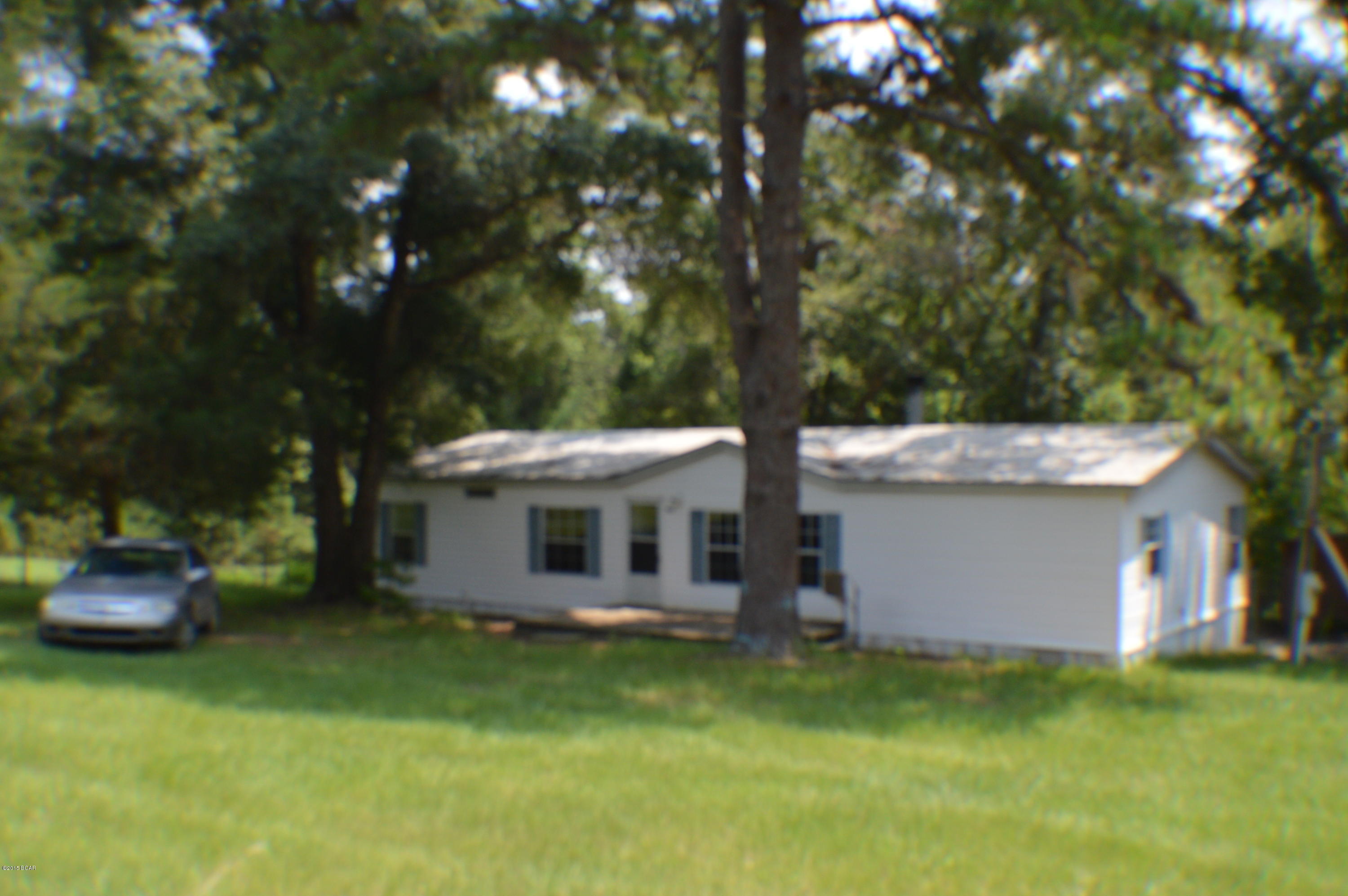 BEAUTIFUL 16 ACRES WITH A 3/2 DOUBLE WIDE HOME SOUTH OF CHIPLEY. THE HOME HAS A NEW METAL ROOF, NICE COVERED BACK DECK AND A FRONT PORCH. HOME HAS A NICE WOOD BURNING FIRE PLACE AND LARGE KITCHEN WITH APPLIANCES. HOME HAS NEW LAMINATE FLOORING THROUGHOUT THE HOME. MASTER BATH HAS SEPERATE SHOWER AND GARDEN TUB. THE PROPERTY HAS 2 WELLS AND A SPRING AND ALSO A WORKSHOP WITH A 2 CAR CARPORT. THIS PROPERTY IS A MUST SEE REALLY NICE.