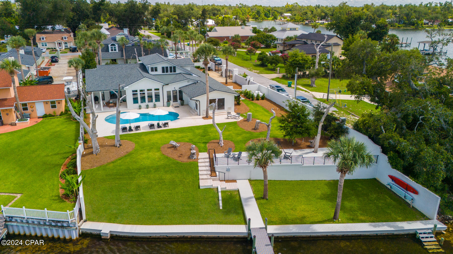 CURRENTLY UNDER CONTRACT, SELLER ACCEPTING BACK UP OFFERS. Welcome to an exquisite private WATERFRONT estate, where transitional finishes seamlessly blend with modern luxuries. Situated on over half an acre with 100 feet of water frontage, this home offers unparalleled south-facing bay views and breathtaking sunsets. The lifestyle here is all about the water—whether it's diving into the pool after a day at Shell Island or relaxing on the back patio with a year-round sea breeze.

This gated waterfront state ensures ultimate privacy with lush landscaping, a boat dock and lift, pool and 4,189 square feet of living space. Inside, you'll find exceptional finishes, including white oak, oiled-finish hardwood floors throughout, a Chef's kitchen with exquisite water views, and spacious interiors. This home features 3 bedrooms, 4.5 baths, a bonus game room/flex room with wet bar, a 600-bottle, foam-encapsulated and temperature-controlled wine room, and a home office, making it the perfect forever home on the water.

Recently renovated with the highest quality of construction, this contemporary and modern design spans mostly one level, offering expansive outdoor living areas, an incredible boat dock and boat lift, and a luxurious pool. The 2019-built dock is designed for boating enthusiasts, featuring high-end ThruFlow grated decking, a 10k lb Golden boat lift with a covered boat house, low-profile solar lighting, security motion cameras, and ample gear storage.

Upon arrival, a gated entrance with natural native landscaping and the soothing sounds of the Bay welcome you. The outdoor entertaining area includes multiple seating areas, a 36'' Cowboy Cauldron Fire Pit next to the pool, and plenty of space for activities like boating, kayaking, paddleboarding, fishing, and sunbathing. This location is well-known for it's proximity to the new sports complex that residents can enjoy including pickleball, basketball and a dog park. This home is also just minutes from Tyndall Air Force Base as well as a short drive to the World's Most Beautiful Beaches!

As you step into the charming covered entry, you'll be captivated by the meticulous millwork and stunning waterfront views. The great room, with its high ceilings and full-glass windows and doors, leads to covered and open patios where you can enjoy both the pool and the Bay. The Chef's kitchen, located just off the living area, features an oversized island, high end Samsung stainless appliances, and a walk-in pantry. The dining room, open to the living room, connects to a 600-bottle capacity custom wine room, making this home ideal for entertaining on the waterfront.

This estate offers everything Florida's waterfront lifestyle has to offer, making it the perfect sanctuary for those seeking luxury and tranquility. Don't miss this opportunity to live your best life...on the water in Panama City, Florida!
