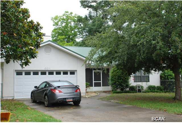 This very well-cared-for home and the adjacent lot are now available in the desirable Lynn Haven area. As you welcome your guests to this wonderful home, the first feature you will notice is the peaceful screened porch - perfect for morning coffee or relaxed reading time. As you enter the home, the living room is very large, has a vaulted ceiling for an even more expansive feel and features a corner fireplace. The fireplace has gas lines available as well. The kitchen is open and bright with a breakfast bar and newer appliances including dishwasher, flat-top stove, built-in microwave and refrigerator. The tiled kitchen overlooks the dining area - large enough for a table for six to eight and a hutch. The master bedroom is another large room with a walk-in closet and sitting area. There