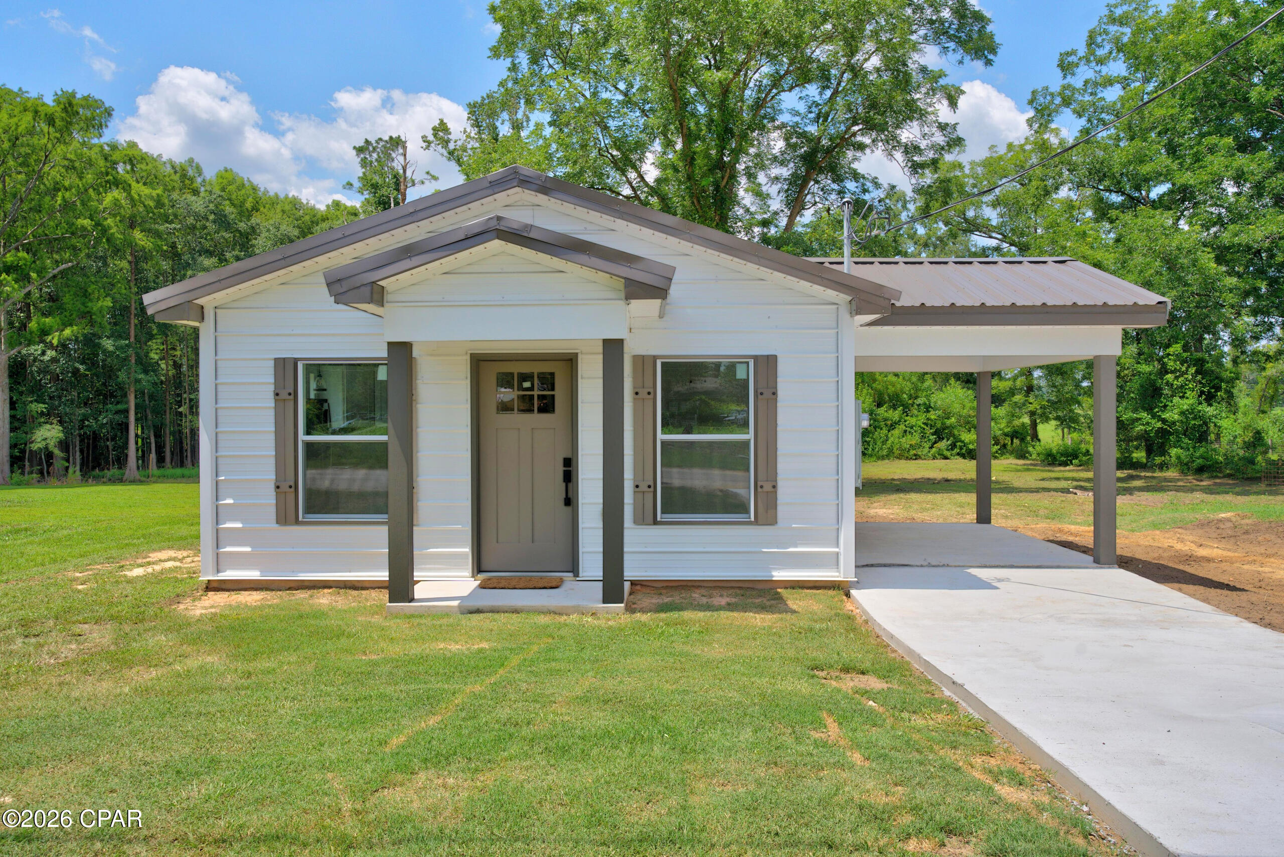 BRAND NEW CONSTRUCTION tiny home offering low-maintenance living with thoughtful features throughout! Built with eco-friendly metal materials that are 67% recycled, this home features a durable metal roof, metal siding, central heat and air with heat pump, a tankless hot water heater, appliances, stained concrete floors, and double-pane Florida-rated windows. The kitchen includes granite counters, solid wood cabinets, soft-close cabinets and drawers, and a lower carousel cabinet ideal for canned goods. Designed to meet all current Florida building and energy codes, this home may also qualify for some of the lowest insurance rates in the area. The bedrooms include shelving already in place for added storage, the laundry area features a cabinet for extra convenience, and the bathroom offers a walk-in shower. Enjoy the covered front entry, convenient side entrance, carport, concrete drive, and plenty of backyard space with room to add a fence. Survey will be provided by closing. Seller is offering a standard 4-year home warranty with an acceptable offer, giving buyers added peace of mind.A great option for those looking for efficient, modern living with practical extras already in place!