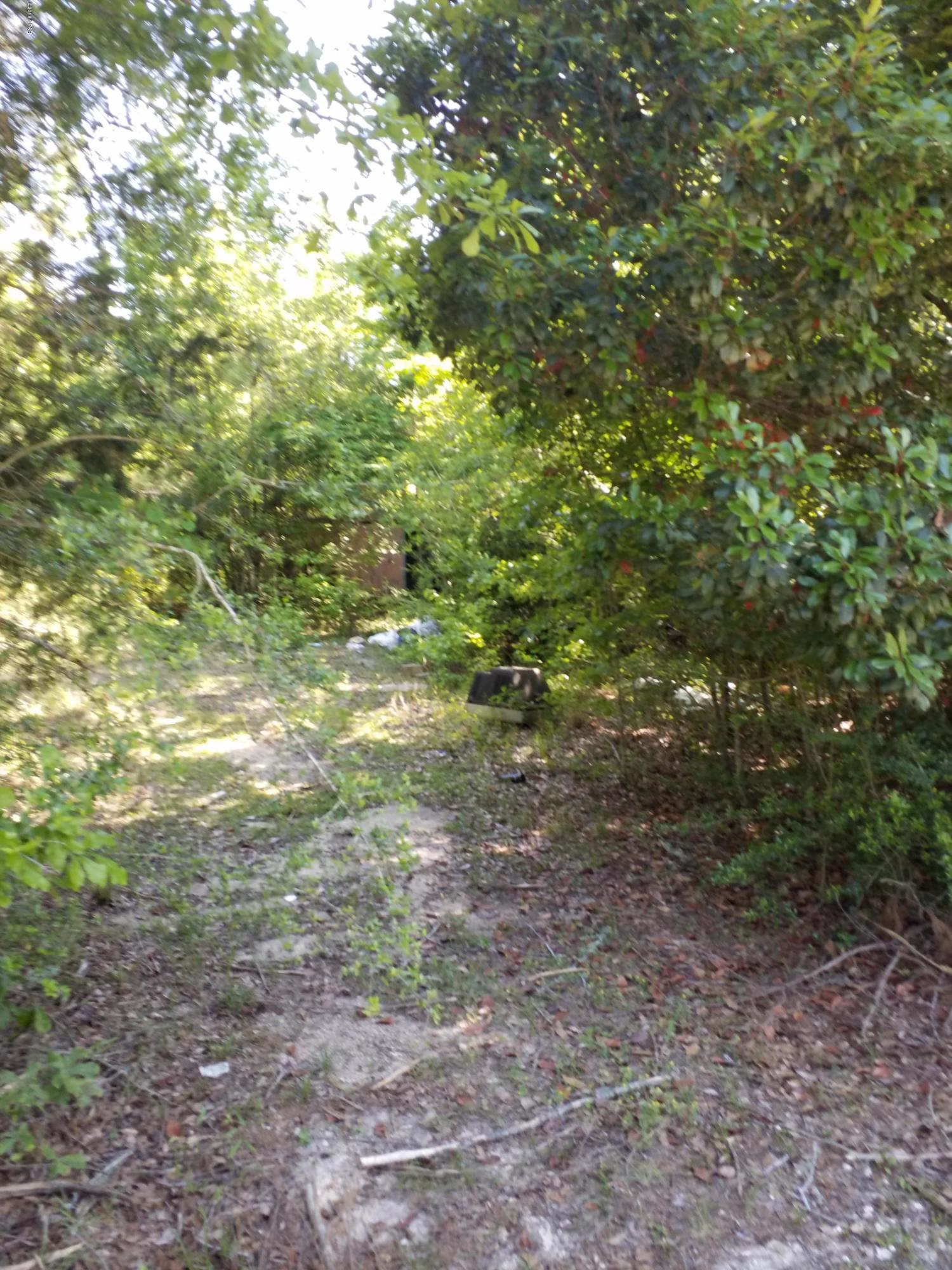 This 1.5 Acre parcel is ready for new owners. Power pole, well, and septic. Will need inspection and possible repair. Owner has no knowledge of condition.  The single wide, and yard building have no value and will need removal. Great location, corner lot. Go show.