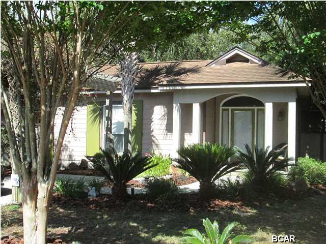 This is the BEACH COTTAGE for you! From the front sitting porch to the pergola over the driveway, this home will draw you in! Furnished as though it came out of a magazine, the 2 bedroom, 2 bath home also has a bunk room with French Doors for privacy. There are 9'ceiling throughout, tray ceiling in the living area and crown molding, giving an air of spaciousness to the home. Master suite, in the back of the home, has a large bathroom with jetted tub, separate shower and separate vanities. The kitchen is equipped with stove, refrigerator, dishwasher and microwave. This home is beautifully decorated and move in ready! The wooden walkways, outdoor shower, decking, covered porch, fire pit, shade trees and privacy fence add a great deal of character to the landscape. This is a perfect  place for that beach get-a-way or to downsize to a cozy, beautiful home. The home is within walking distance of the beach in a quiet neighborhood at the west end. Definitely a home you want to see.