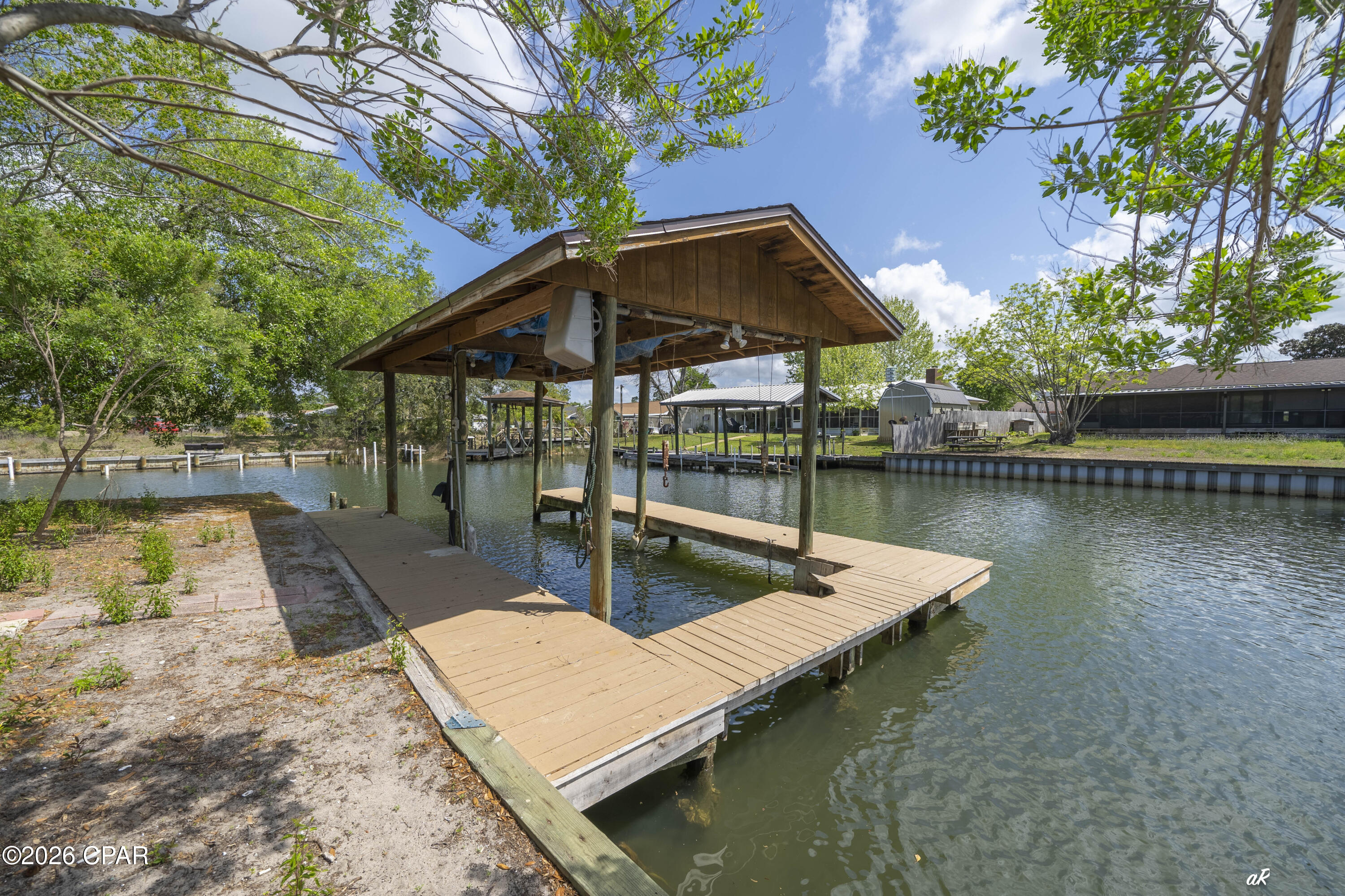 UNDER CONTRACT WITH CONTINGENCIES; SELLER ACCEPTING BACKUP OFFERS.

DEEP WATERFRONT LIVING WITH DIRECT GULF ACCESS (10 MINUTE BOAT RIDE TO WEST BAY, 10 MINUTES TO ST. ANDREWS BAY, 17 MINUTES TO SHELL ISLAND) - BRING A BIG BOAT - NEVER WORRY ABOUT WAITING FOR THE RIGHT TIDE.
Your best life awaits at 1311 Capri Drive, Panama City, FL. This expansive 4-bedroom, 2.5-bath home on a corner lot blends coastal convenience with thoughtful upgrades and flexible indoor/outdoor living.

Highlights:
Private dock with a 10,000 lb boat lift on the corner and quick access to open water ideal for fishing, cruising, and sunset outings. Canal depth 20'.
Versatile floor plan: living room, den, and a bright Florida room provide multiple spaces to relax or entertain.
Recently remodeled kitchen with tile backsplash, easy-clean appliances, large pantry, and exposed ceiling beams open to wide living and dining areas with hardwood flooring throughout.
Two stone fireplaces, including a striking double-sided unit between sliding glass doors that opens to the main deck.
Large first-floor laundry room and crawl space under the stairs; open-air patio at the first entry and multiple entrances off the deck for seamless indoor/outdoor flow.
Spacious back porch with a fish-cleaning station perfect for anglers and outdoor gatherings.
Second-floor layout features a second master suite with oversized his-and-hers walk-in closets and an additional closet, plus a large private deck with distant West Bay water views. Two guest bedrooms and a shared bath sit conveniently between them.
New exterior paint and well-maintained finishes throughout.
Short-term rental allowed.
Located in an established waterfront neighborhood close to beaches, marinas, shopping, and dining, this property offers true coastal living with easy access to everything the Gulf Coast has to offer. Schedule your showing to experience the lifestyle and waterway access firsthand.