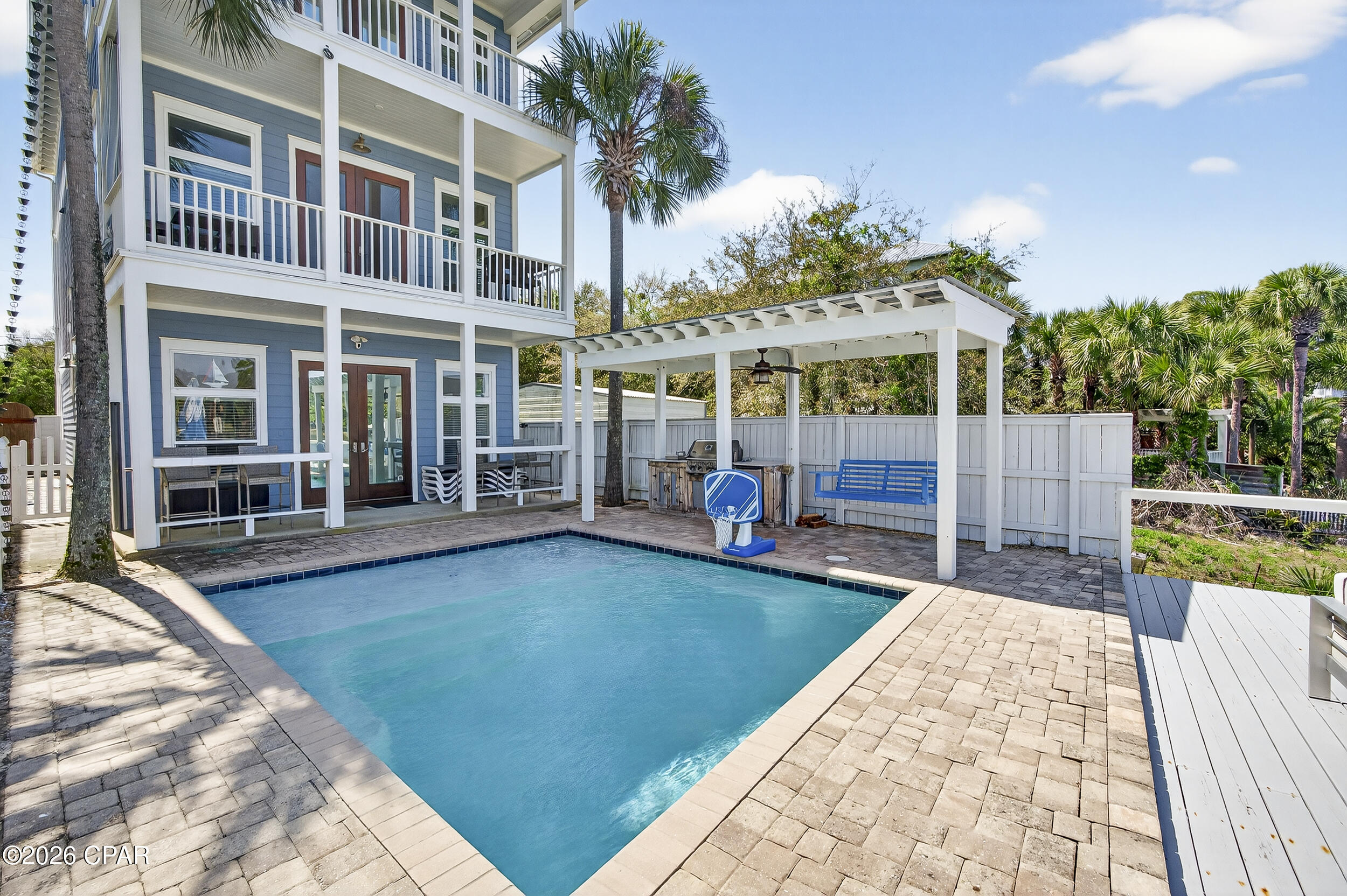 CURRENTLY UNDER CONTRACT, SELLER WILL CONSIDER BACKUP OFFERS. Where boating days meet barefoot beach mornings - this custom-built waterfront home on Grand Lagoon captures the best of Panama City Beach living. Positioned as an end residence with no neighbor to the west, it offers added privacy in a quiet, golf cart-friendly neighborhood where you can step onto your private dock or be on the sand in under 5 minutes via Public Beach Access #21. From here, it's an easy ride or walk to nearby shopping, dining and entertainment including local favorites like Schooners and Harpoon Harry's, giving you a lifestyle that's both relaxed and connected.

Spanning three levels, this 4BR/4BA residence blends upscale craftsmanship with thoughtful functionality. Brazilian cherry flooring and mahogany doors are complemented by granite countertops and custom cabinetry throughout, while 10-foot ceilings and 8-foot doors create a warm, refined aesthetic. Expansive living spaces and multiple balconies maximize views over the Gulf and Grand Lagoon. A hydraulic elevator services every floor, adding a level of everyday convenience that's hard to overstate - whether bringing in groceries or making multi-level living more accessible and effortless.

Two separate living areas offer flexibility to spread out and unwind, creating distinct spaces for relaxing or hosting. The designer kitchen is built to gather, featuring top-of-the-line appliances and an open layout that flows seamlessly into the living area and oversized balcony overlooking the water. The primary suite opens to a private waterfront balcony and features a spa-inspired bath with a frameless glass steam shower and jacuzzi tub. Each additional bedroom offers its own private balcony and a bath with a jacuzzi tub, while a top-floor guest suite lives like a second primary.

Outside, the Florida lifestyle takes center stage. The heated saltwater pool with sun shelf, bubblers, and umbrella ledge invites long afternoons in the sun, while the covered lanai and outdoor kitchen create the perfect setting for gathering. The private dock with remote-controlled boat lift (accommodating approximately up to a 10' beam and 30' vessel) includes shore power, water, and cable - putting Shell Island, St. Andrews Bay, and the Gulf just a short 15-minute ride away. Spend your days fishing, dolphin watching, or anchoring out for a beach day with the family.

Additional highlights include two laundry rooms (first and third floors), a whole-house Generac generator (2021) for added peace of mind, hurricane-rated windows and doors, smart home features (Ring cameras, connected locks and lighting), a new paver driveway (2022), and a one-car garage.

Offered fully furnished with high-quality, homeowner-grade pieces (with just a few minor personal exclusions; golf cart and fishing equipment negotiable), this home is move-in or rental ready. It has not been used as a rental by current or previous owners, offering a well-maintained, lightly used opportunity.

If you're looking for a waterfront home that feels tucked away yet keeps you close to the beach, dining, and everything Panama City Beach has to offer, this one delivers. Schedule your private showing to see it firsthand.