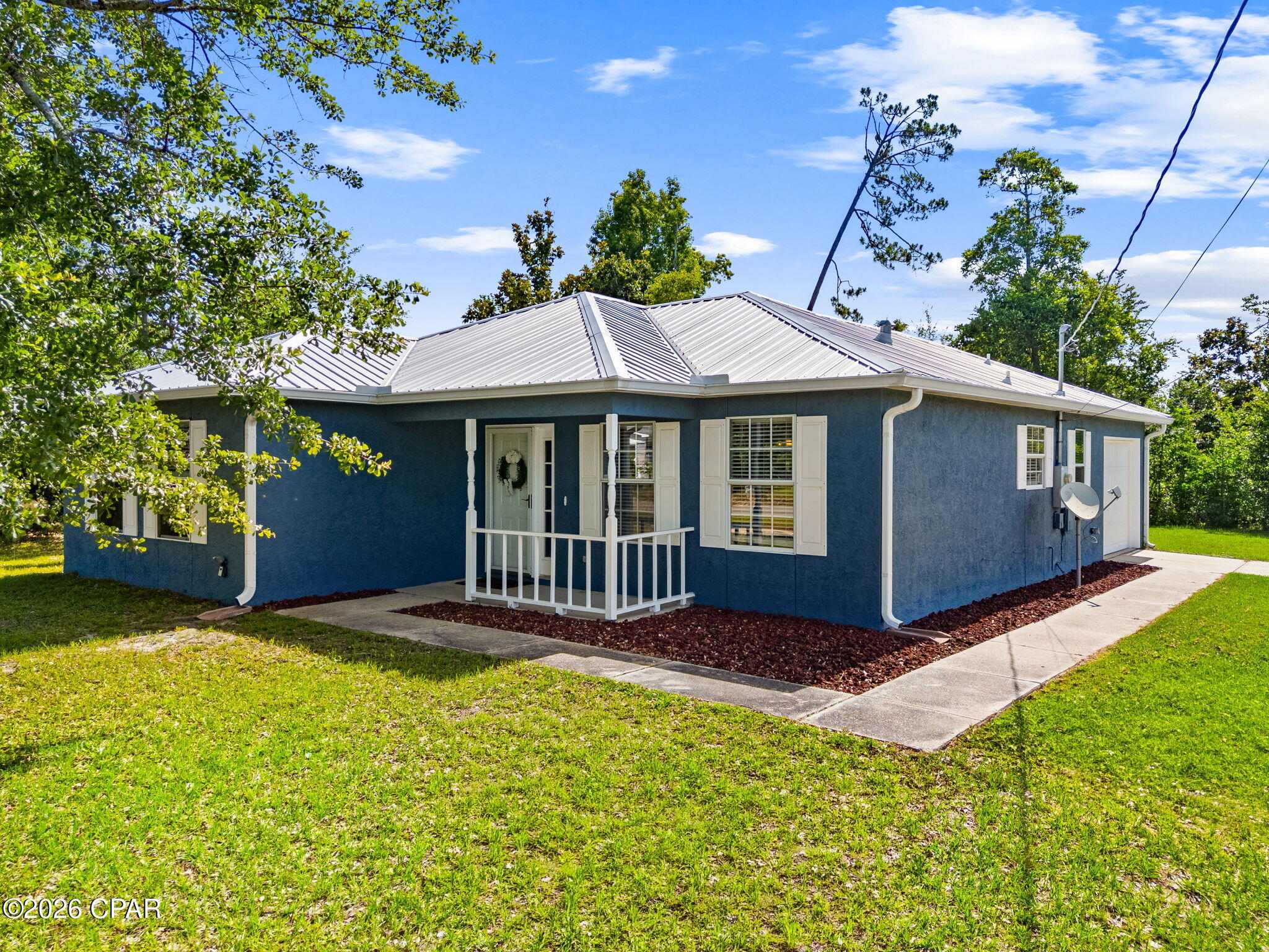 Well-maintained 3BR/2BA home situated on a spacious 100' x 150' corner lot in the heart of Lynn Haven. Conveniently located within walking distance to Cain Griffin Park, featuring pickleball courts, playgrounds, ball fields, and new neighborhood sidewalks. Major updates include a metal roof (2019), HVAC system (2019) with annual servicing, water heater (2020), and freshly painted exterior (2025).

The interior offers a bright living room with abundant natural light, a functional kitchen with ample cabinet storage, and a large laundry room with additional storage space. All kitchen appliances convey. The primary suite features a walk-in closet, double vanity, tub/shower combination, and French doors leading to the back patio. Two additional bedrooms share a hall bathroom with a tub/shower combination and nearby linen storage.

An oversized one-car garage provides additional storage and workspace. The expansive lot is shaded by mature trees and offers privacy, along with plenty of room for outdoor living, gardening, or future improvements. Located in desirable school zones and just minutes from shopping, dining, and everyday conveniences, this property presents an excellent opportunity to own a move-in-ready home in a sought-after Lynn Haven location. *All information and measurements approximate, verify if important.
