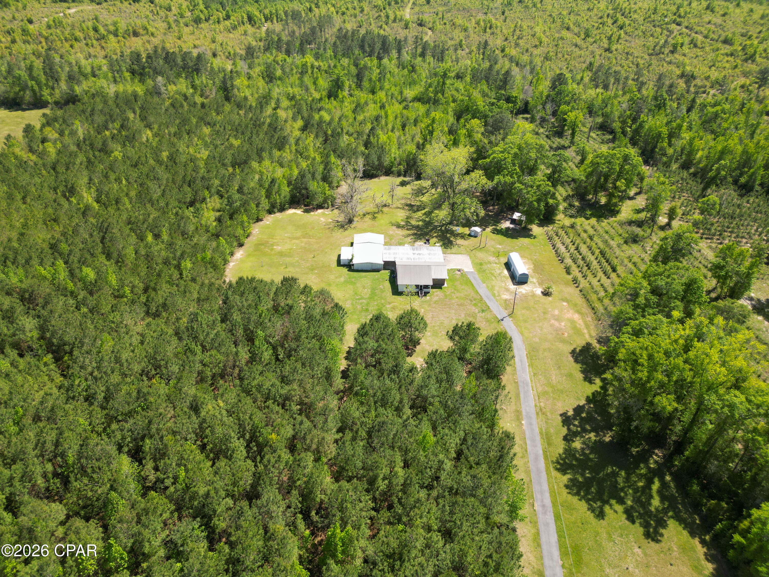 Welcome to 2527 Frost Lane in Chipley, a spacious 2-bedroom, 2-bathroom home offering 2,634 square feet of living space on 20.50 beautiful acres just off Pioneer Road, providing quick and convenient access to Highway 77. The home features a durable brick and vinyl exterior with a metal roof, along with a flexible floor plan that offers the potential to be reconfigured into a 3-bedroom, 2-bathroom layout. One of the bedrooms includes an attached space that could easily serve as an office, sitting room, nursery, or additional bedroom, depending on your needs. The property offers an abundance of covered parking, including an attached garage with space for at least three vehicles, as well as an attached carport with room for multiple additional vehicles, equipment, or recreational toys. Outdoors, you'll find eight pecan trees and plenty of room to enjoy the peaceful setting. The land includes two wells, one of which is not currently working, and three septic systems, offering the possibility for a second homesite with county approval. With a 5-year-old HVAC system, generous acreage, versatile living space, and exceptional parking and property features, this unique Chipley property is full of potential.