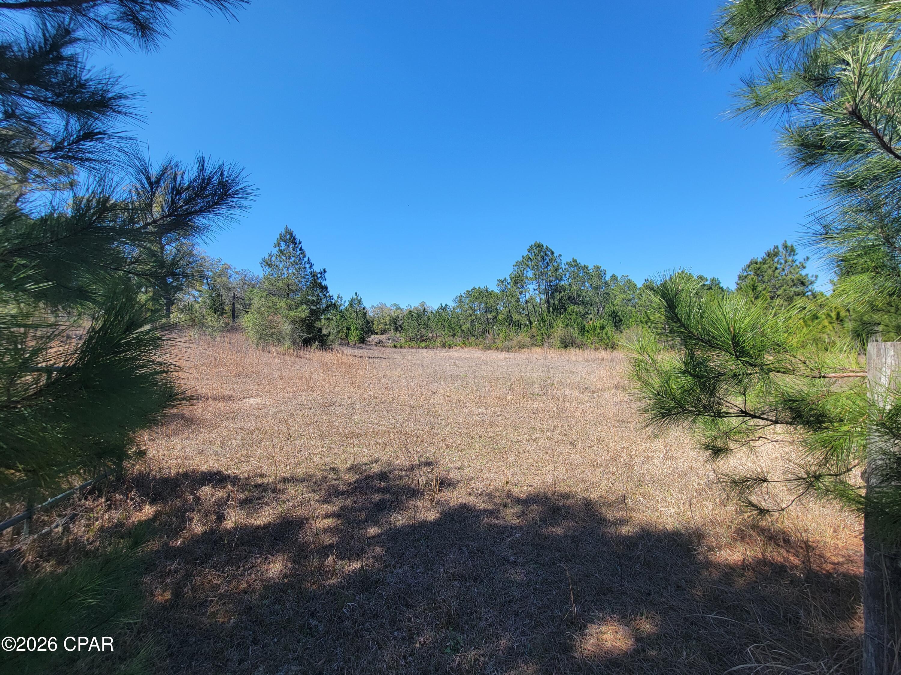 BEAUTIFUL 16-acre property located near Compass Lake, just across Highway 231, offering peaceful country living with distant lake views. Located just half a mile from the public boat ramp at Compass Lake, you'll enjoy easy access to boating, fishing, and outdoor recreation. This absolutely gorgeous tract features four natural spring-fed ponds, established fencing suitable for horse pasture, and trails perfect for riding side-by-sides or enjoying the outdoors. The property offers a rare combination of seclusion and convenience, situated on a paved road while still providing privacy and room to roam.

Zoned AG-2 with no known deed restrictions, the property allows for one dwelling per acre, making it an excellent opportunity for a private estate, family compound, or future development potential.

Enjoy the beauty of North Florida while still being conveniently located just 12 miles from the I-10 Cottondale exit and approximately 45 miles from Panama City Beach.

If you're looking for a versatile piece of land with water features, usable pasture, and stunning natural surroundings, this property is a must-see. Recently surveyed for clearly defined boundaries and added peace of mind.