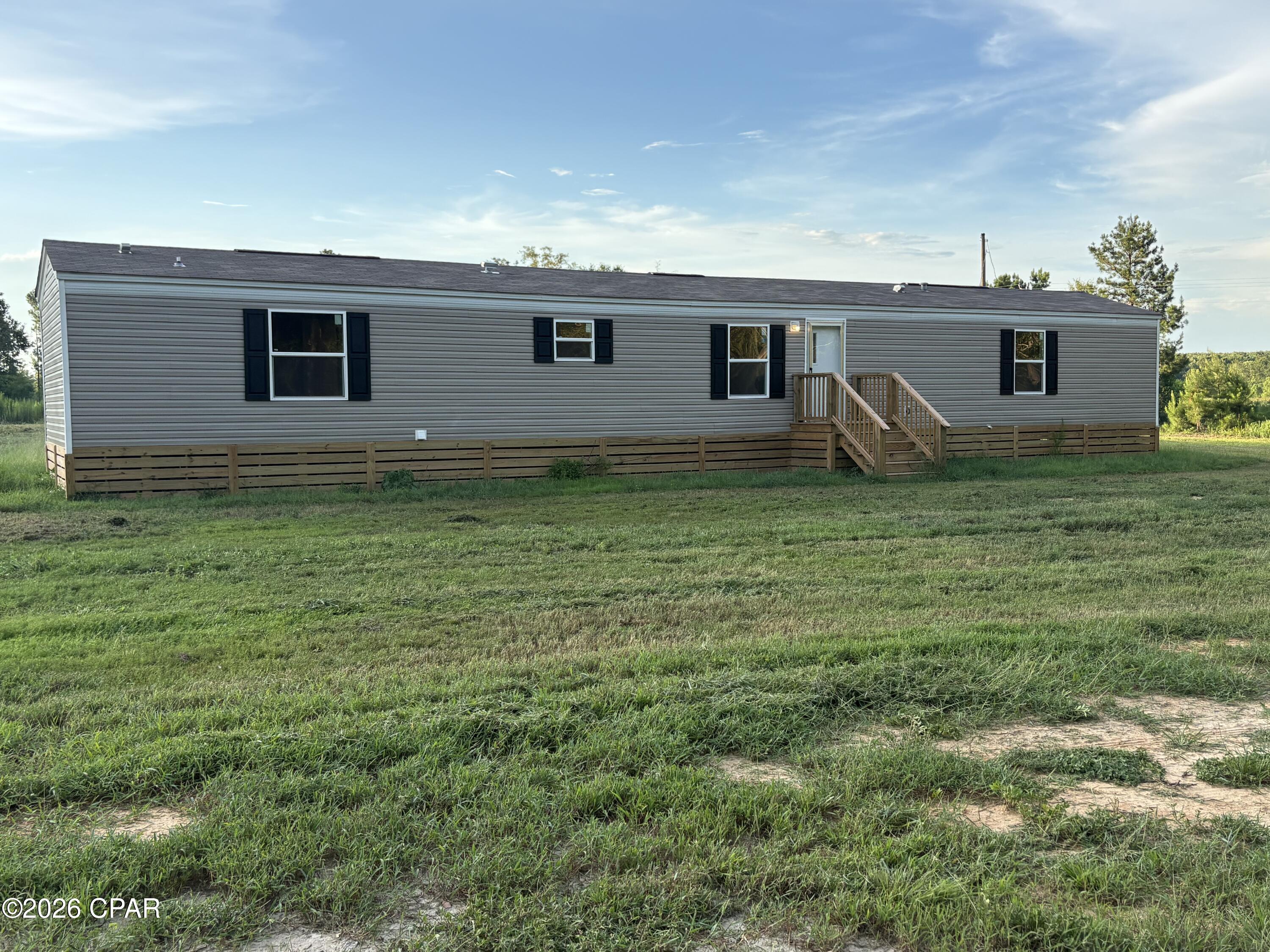 New (2024 model), never lived-in before, 14x80 Clayton single wide mobile home. This home is 3 bedroom/2 bath, approximately 1100 sq. ft., and sits on approximately 2.75 acres. This home is conveniently located less than 50 yards off a paved road but with dirt road drive-way access for more privacy, and you have a wooded view from your front door across the road!  With about 245 feet of highway frontage on the right side of home, you could install a culvert and add an additional driveway from the paved road for added convenience. Brand new well and septic tank is a bonus! New wood skirting and new decks on both the front and back of home provide a warm and inviting feel. The home has a split floor plan with an open access kitchen/dining and living room in the center of the home, and the master bedroom and guest rooms are on opposite ends. There is a large utility room and even a flex space for a desk, small sofa, or reading nook between the two guest rooms!  The master bedroom has a large walk-in shower, a tub for relaxing, and also a large walk-in closet big enough for two!  A washer/dryer/utility room is conveniently situated next to the master bedroom. A large island sits in the middle of the kitchen with a grand view to the outdoors through a sliding glass door which leads to the rear deck. There are some nice mature trees in the front yard next to the highway giving you a buffer zone and adding to the curb appeal.