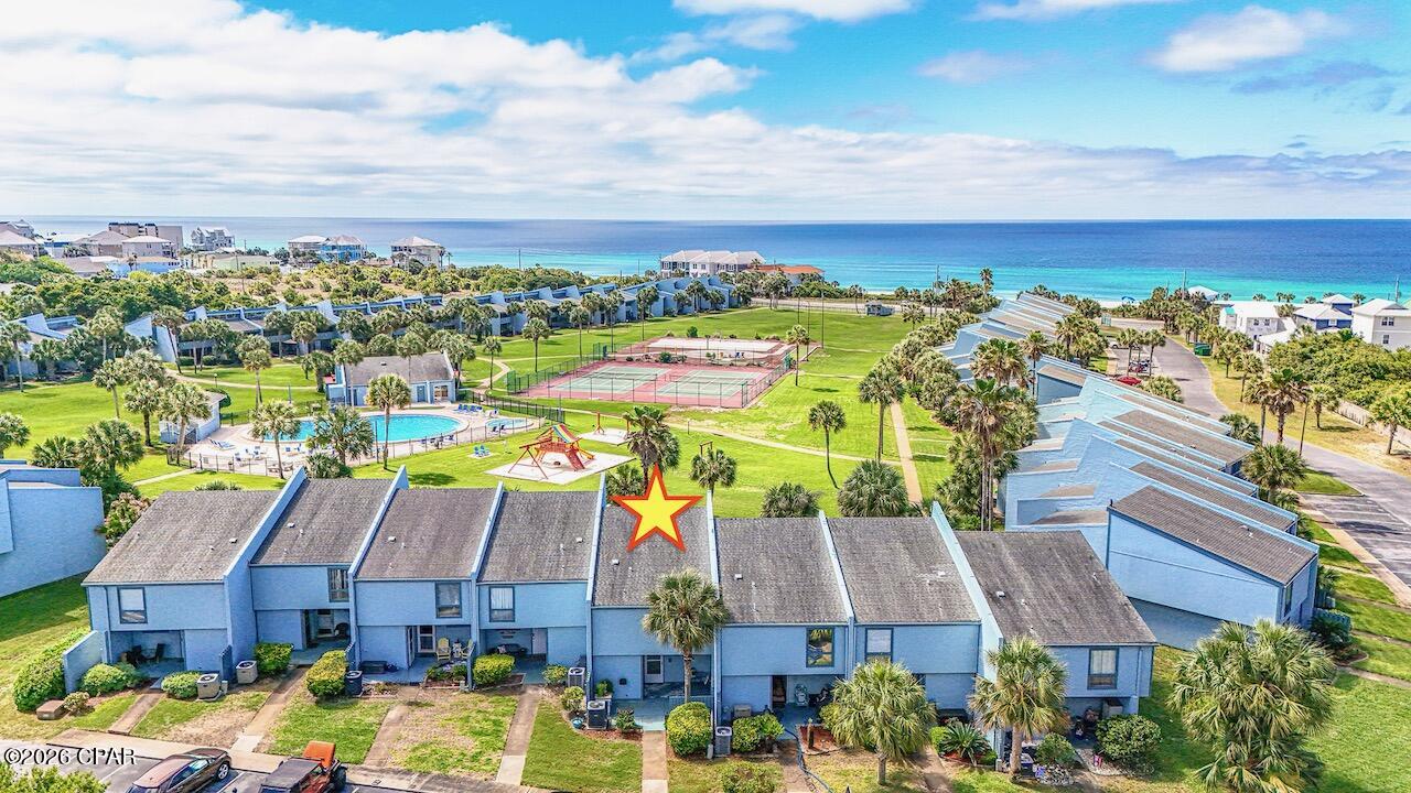 JUST REDUCED! This incredible Sunnyside condo sleeps 10! They rarely come on the market, especially with a dedicated beach with private gazebo/viewing area to relax and enjoy the sunsets! This updated unit is 4th from right on bottom of ''U'' with wide panoramic view of the green! Located 350' from the Gulf.

The Sellers thought this was going to be their forever home so it was never used as a rental! This fully renovated unit has new lighting throughout, kitchen has custom tile backsplash w/ 15'' deep solid wood white cabinets w/ soft-close/deep drawers w/ dove-tailing combined w/ a beautiful quartz countertop. Custom solid wood beadboard added on adjacent wall to blend w/ existing. Deep stainless steel sink w/ dimmable light above, newer dishwasher, custom pots & pans drawers, too! Custom painted in 2024 w/ upgraded scrubbable paint & 6'' baseboards added! Stairwell updated in 2024. All doors and windows are solid wood trimmed. Condo faces South to get full light all day. Back wall has 90% UV protection screens even tho the sun does not beam in. Nice sized LR with queen sofabed and enough room to add an extra chair. The 16' high ceiling adds so much room to this already nice sized condo! Don't miss the high tongue and groove solid wood ceiling! Spectacular feeling when entering! DR seats 6 with a bench that can be added for extra guests! 1/2 bath downstairs with new cabinet and lighting. Laundry room behind it with full sized W/D. Laundry room exterior door is 36'' wide as is front door. Storm door added to enjoy fresh air.  Large walk-in owners closet. Nest thermostat. Loft area has a queen Murphy bed with beams above to blend with LR area. Some electrical outlets moved for convenience. Large Primary BR with wood beams and bottom up/top down custom shades as well as ensuite bath with updated tile shower. Guest BR has white solid oak single bunk beds with queen bed with custom storage cabinets above closet. Some units have the Guest BR with glass windows looking into the LR - this room is private! Also extra cabinet storage space in hallway.  New thick carpet in bedrooms w/ upgraded padding. Both baths are renovated w/ new lighting, tile flooring, vanity cabinets w/ soft close drawers.  Guest bath has bathtub/shower combo. Patio in front for relaxing as well as large patio out back to enjoy the incredible view! There is 24-hour service available daily whether it be maintenance or office manager on site. Security guard on site throughout the week. The HOA maintains the outside painting & roof, with internet, trash and water included. Sunnyside Beach & Tennis Resort is a tranquil escape located on the quiet side of PCB. Situated amidst lush greenery, this tropical paradise encompasses 18 acres within 350 ft. of the emerald colored Gulf waters and sugar white sand beaches. The unique quality of this resort is the dedicated beach access. The underpass is a well-lit tunnel under Front Beach Road which leads to the large gazebo and boardwalk that sits on the white sandy beach! The complex amenities include: tennis courts, shuffle board courts, 2 pools (one for the little ones), a playground, and a clubhouse which features: free Wi-Fi connectivity, ping-pong table, and pool table and its very own private view of the Gulf. Come see this gem of a condo!  Make it your home! No RV parking, only boat trailers and enclosed trailers, maximum 30' located in private lot beside condo. (Some personal knick knacks do not convey and some items in pictures were used for staging)