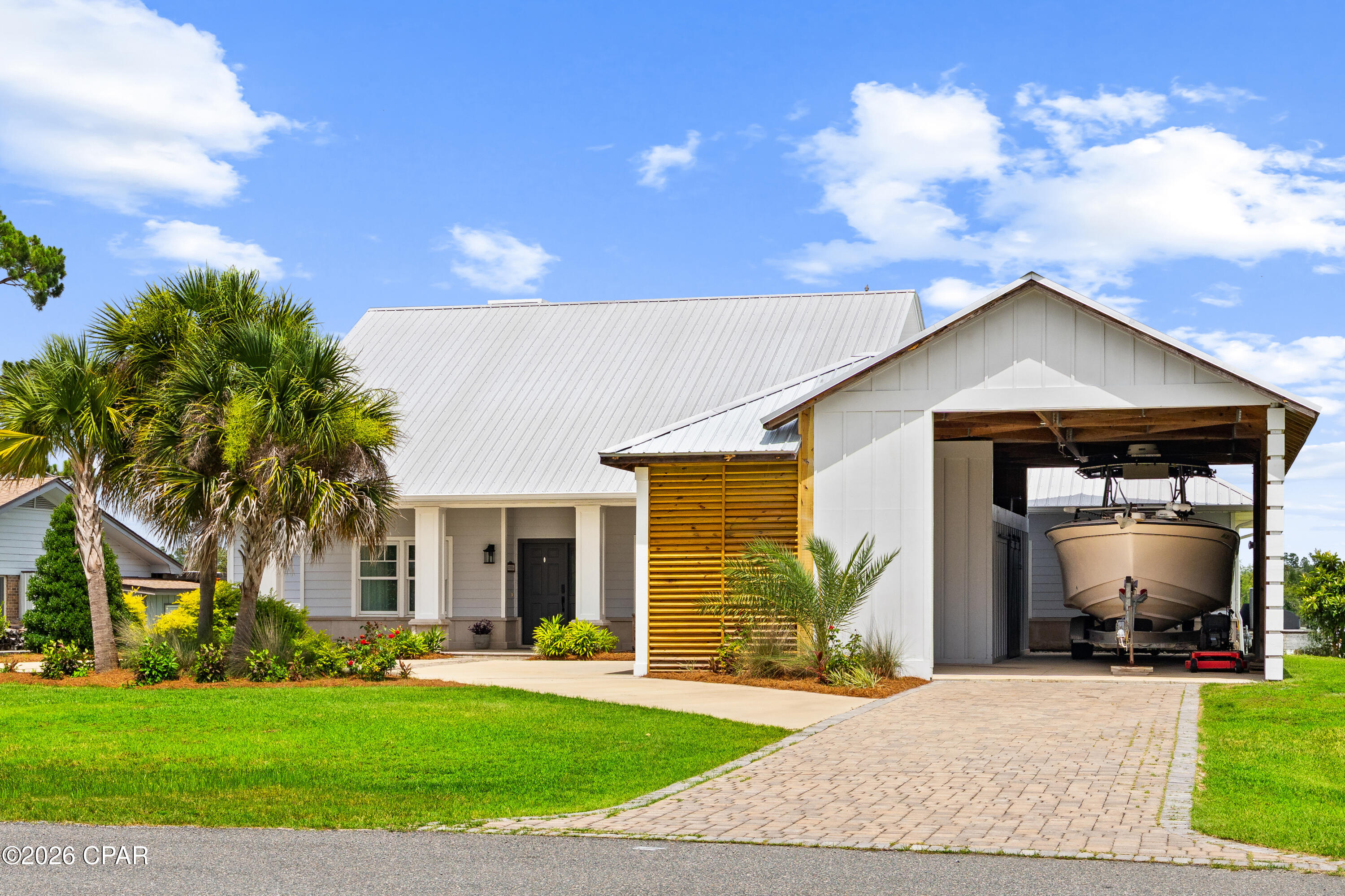 Experience waterfront living at its finest on picturesque Mill Bayou, offering deep-water access to the Gulf and an exceptional blend of luxury, comfort, and coastal charm. This beautifully crafted Cape-style residence welcomes you with classic Southern architecture, highlighted by expansive covered porches and impeccably maintained landscaping that create a stunning first impression.
A newly added oversized covered parking pavilion provides ample space for multiple vehicles, a large boat, RV, or recreational equipment, while the elegant wraparound driveway enhances both convenience and curb appeal. The professionally landscaped grounds offer a private, estate-like setting that perfectly complements the home's waterfront location.
Designed for both everyday living and entertaining, the home features rich bamboo flooring throughout the main living areas, soaring ceilings, and a thoughtfully designed open-concept floor plan. The chef's kitchen is a true centerpiece, showcasing stainless steel appliances, a six-burner gas cooktop, an oversized island with seating, and custom finishes throughout. Adjacent to the kitchen, the spacious butler's pantry and laundry room provide exceptional storage and built-in washer and dryer accommodations.
Step outside to your private waterfront retreat where a large covered deck overlooks the tranquil bayou. Entertain guests with ease in the fully equipped outdoor kitchen featuring a Big Green Egg, oversized pergola, and beautifully designed raised garden beds, all while enjoying breathtaking water views.
The luxurious primary suite serves as a peaceful sanctuary with serene bayou vistas. The spa-inspired ensuite bath is beautifully appointed with marble finishes, a soaking tub, dual vanities, a separate walk-in shower, and an extraordinary custom walk-in closet with built-in organization systems.
A desirable split-bedroom layout offers privacy for family and guests, with two additional bedrooms and a full bath located on the opposite side of the home. A versatile front room can serve as a sophisticated home office, library, or formal dining space. Upstairs, a massive bonus room offers endless possibilities and has been pre-plumbed for a future full bath, making it ideal for a guest suite, media room, or additional living quarters.
The spacious backyard provides plenty of room for a custom in-ground pool, allowing you to create the ultimate waterfront oasis. Wake each morning to spectacular sunrises over your private estuary, then spend your evenings cruising by boat to the bay to enjoy unforgettable Gulf Coast sunsets. This is a rare opportunity to own a truly exceptional waterfront property where luxury, lifestyle, and adventure converge.