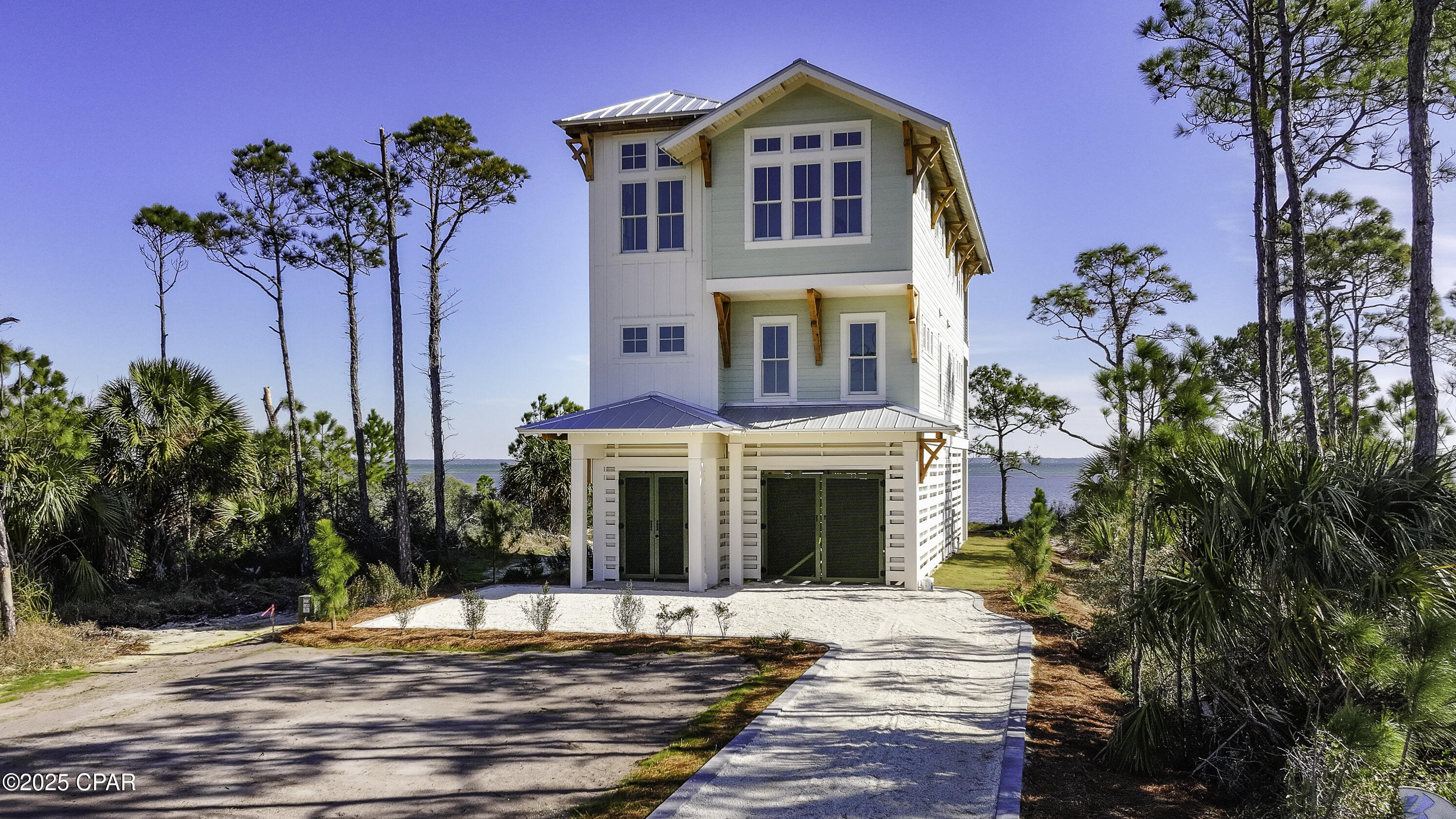 Crafted with precision and passion, this new construction nearly complete coastal gem stands as a beacon of luxury living in the coveted Ovation community, commanding a premium position with breathtaking views over the serene St. Joe Bay. This home, a testament to contemporary design fused with the raw beauty of its surroundings, offers a spacious sanctuary featuring four well appointed bedrooms and 4.5 baths, each a showcase of high-quality materials and meticulous attention to detail. From the moment you step through its doors, the home welcomes you with an entry-level foyer, complete with elevator access to all three floors. The ground floor introduces an open space, ideal as a vibrant game room along with a tranquil outdoor living area. The exploration continues on the second floor, where two junior suites boast en-suite baths and a second living room provides a flexible space for entertainment or relaxation. The third floor unveils an awe-inspiring open concept living area with vaulted ceilings and panoramic views of St. Joe Bay. The heart of this floor is the owner's suite, offering a secluded retreat space perfect for unwinding. The living area extends to a generous deck, inviting you to savor the bay views and immerse yourself in the laidback coastal lifestyle. Experience coastal elegance with a quick golf cart ride to pristine beaches. Enjoy luxury amenities: an infinity-edge pool, hot tub, firepit, fitness center, clubhouse, and boat docks—each crafted for your exclusive lifestyle, just steps away.