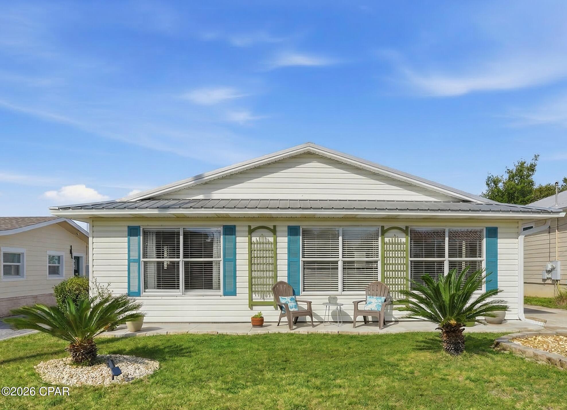 A spacious. excellently maintained cottage style home, located 3 blocks from the beach. An overersized Primary bedroom, 2 additional bedrooms, 1 bathroom. The kitchen, dining room & living area are all connected to create an open living concept with real hardwood flooring. Sold furnished. Off street parking on the extensive driveway for up to 5 vehicles, or a boat & trailer, plus a 2 car detached garage, with workbench & cabinets and with the potential to be an additional Guest Suite. Updated AC 2018, WH 2018 & Metal Roof 2014. Back yard is fully fenced. Located on the West End of Panama City Beach (Public Beach 87) and  located 4 miles east of Scenic 30A & Lake Powell.