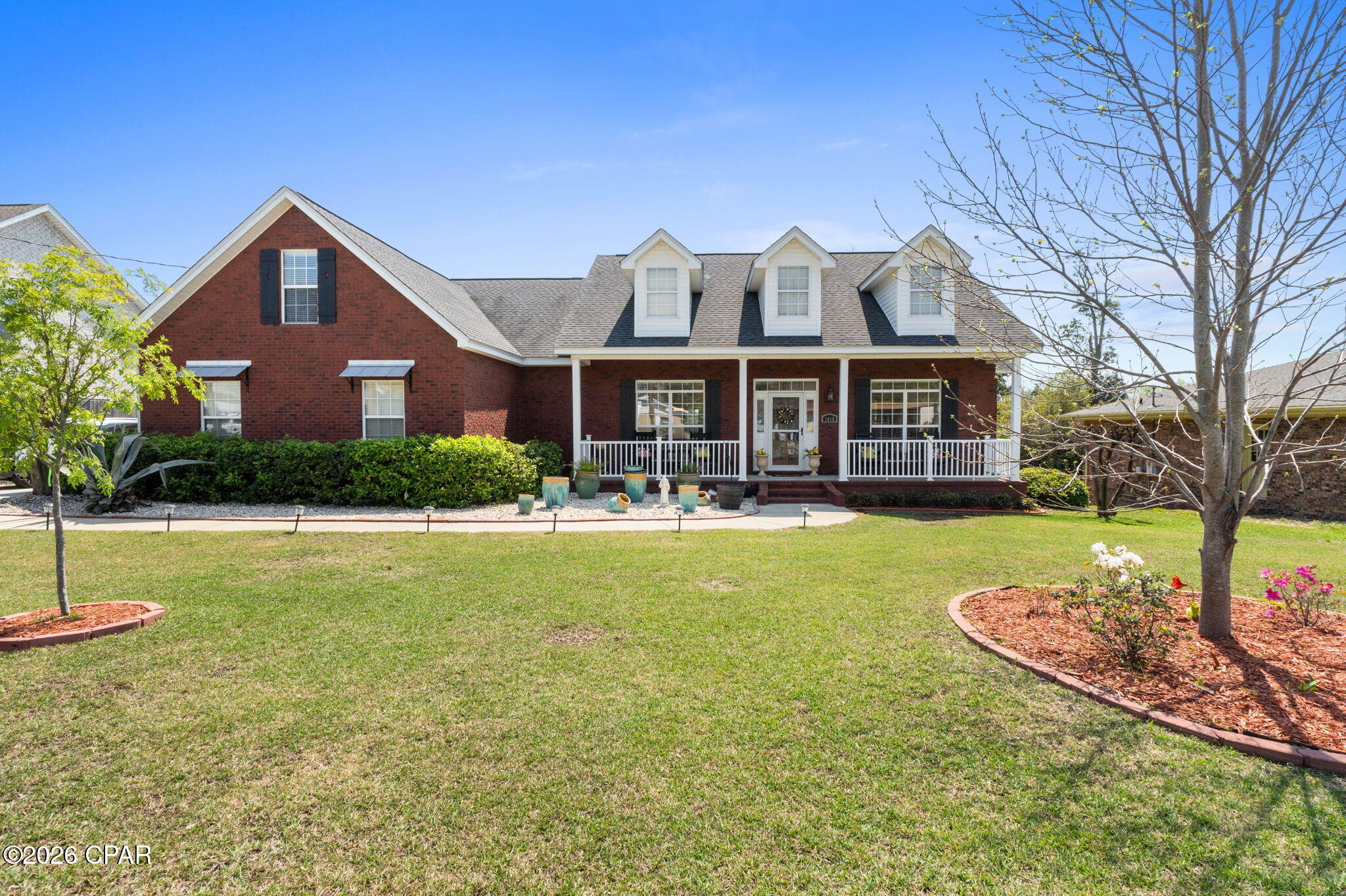 Custom-built, this beautifully maintained all-brick home offers exceptional curb appeal and a prime location just steps from the new Al Helms Dog Park, Garden Club, and a short walk to the Bay and Beach Drive. Conveniently located between St. Andrews and downtown, with quick access to 23rd Street shopping and the beaches. Inside, you'll find a well-appointed gourmet kitchen featuring KitchenAid stainless steel appliances, 2 convection ovens, gas cooktop, custom maple cabinetry, solid surface countertops, and a built-in breakfast nook. The open layout is enhanced by 10-foot ceilings, crown molding, recessed lighting, wood grain tile flooring, and a gas fireplace. Built with quality in mind, upgrades include plywood construction (no OSB), all-brick stem wall, 30-year architectural shingles, and wind-rated garage doors. The home offers abundant storage with an oversized two-car garage, climate-controlled storage room, and a detached 26x14 workshop with 100-amp service and attic space. Enjoy outdoor living with covered front and back porches, a spacious deck for entertaining, and an extra-wide driveway with room for a boat or RV. A rare combination of quality, location, and functionality.