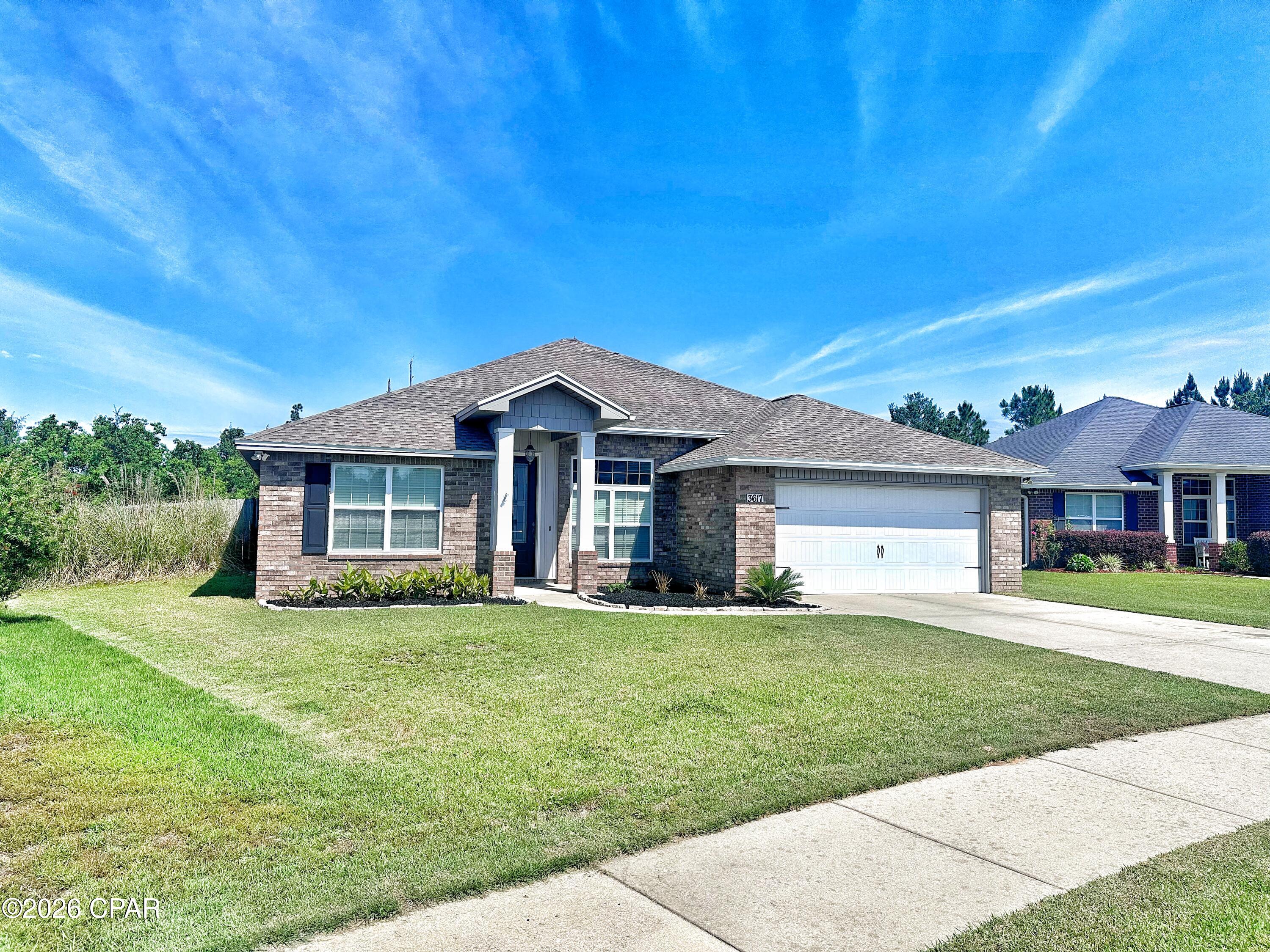 Welcome to 3617 Azalea Court, a beautifully maintained all-brick home tucked away in the peaceful neighborhood of Azalea Place. Perfectly positioned just off the main thoroughfares, this home offers easy access to Lynn Haven, Tyndall Air Force Base, shopping and dining along 23rd Street, St. Andrews, Downtown Panama City, and the world-famous beaches of Panama City Beach.
Situated on the largest lot in the neighborhood, this property backs up to a serene wooded preserve-- no neighbors behind you but the squirrels! A spacious covered lanai overlooks the expansive backyard, which offers endless possibilities--plenty of room for pets, play, a future pool, or storing all your outdoor toys.
Inside, you'll find over 1,900 square feet of thoughtfully designed living space featuring luxury vinyl plank flooring throughout,10-foot ceilings, and elegant custom moulding and millwork. The spacious family room is anchored by a cozy electric fireplace, creating a warm and inviting atmosphere.
The kitchen and living spaces are separated from the main entry by a foyer (for privacy).  Kitchen is ideal for both everyday living and entertaining, showcasing granite countertops, stainless steel appliances, a double oven, pantry, and a generous breakfast bar that flows seamlessly into the dining and family room.
Designed with comfort and functionality in mind, the split-bedroom floor plan provides privacy for the primary suite. A front guest bedroom offers flexibility and would make an excellent home office. The primary suite is a true retreat, featuring a tray ceiling, large walk-in closet, and an en-suite bath complete with a garden tub, separate shower, and dual vanities.
Located in a quiet, family-friendly neighborhood with convenient access to area schools, this home combines space, style, and location--making it the perfect place to put down roots.
