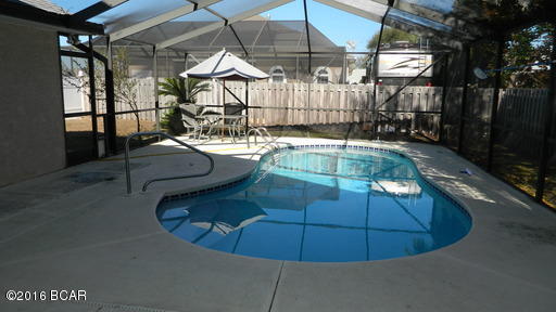 For rent. This 3 bedroom, 2 bath home is perfect for entertaining with an open floor plan, screened pool and large, and covered patio with electric/water hookup to accommodate a hot tub. Located in the desired neighborhood, Summer Breeze, the property is just a few minutes away from the nearest beach access point. It is also located a few miles from Pier Park shopping, restaurant, and entertainment facility. The home is situated on a corner lot with fence to provide optimal privacy while giving a nice spacious yard. The interior features hardwood floors throughout the home. The master suite offers a walk-in closet, private entry door to pool and master bath with double vanities, jacuzzi tub, and large separate shower with seat.  The kitchen has plenty of cabinet space, glass cook top, dishwasher, side-by-side refrigerator with ice maker, and microwave/vent. There is also a spacious pantry/laundry room attached. The living room has a gas fireplace with custom, built-in cabinetry on both sides. There is a gas hookup on the back patio for a grill, so no more hauling the gas tank to the nearest store. Pool service included with rent. Pet negotiable with $500 non-refundable pet fee. Please contact our office to schedule an appointment today!
