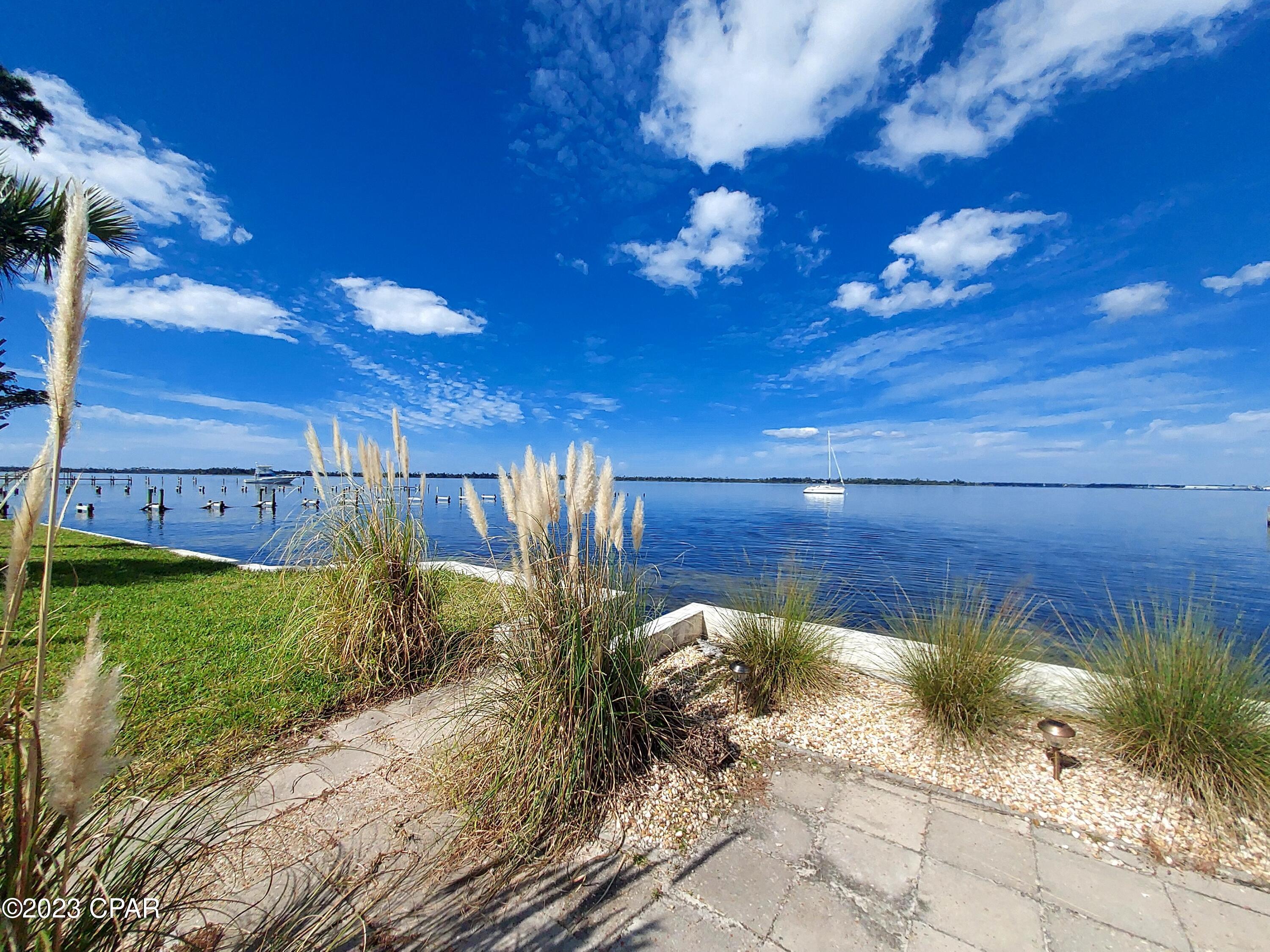 Absolutely amazing Florida cottage nestled directly on St. Andrews Bay facing West to enjoy the most spectacular sunsets!  This cottage features two bedrooms, tonged and groove walls and ceilings with original terrazzo flooring. The kitchen plenty of cabinet and counter space with the dining room just off of the kitchen and around the corner from the expansive living room.  You can see the water from all three of these rooms!  There is a covered porch that faces the water, good size storage shed and covered parking along with separate laundry room with washer and dryer.