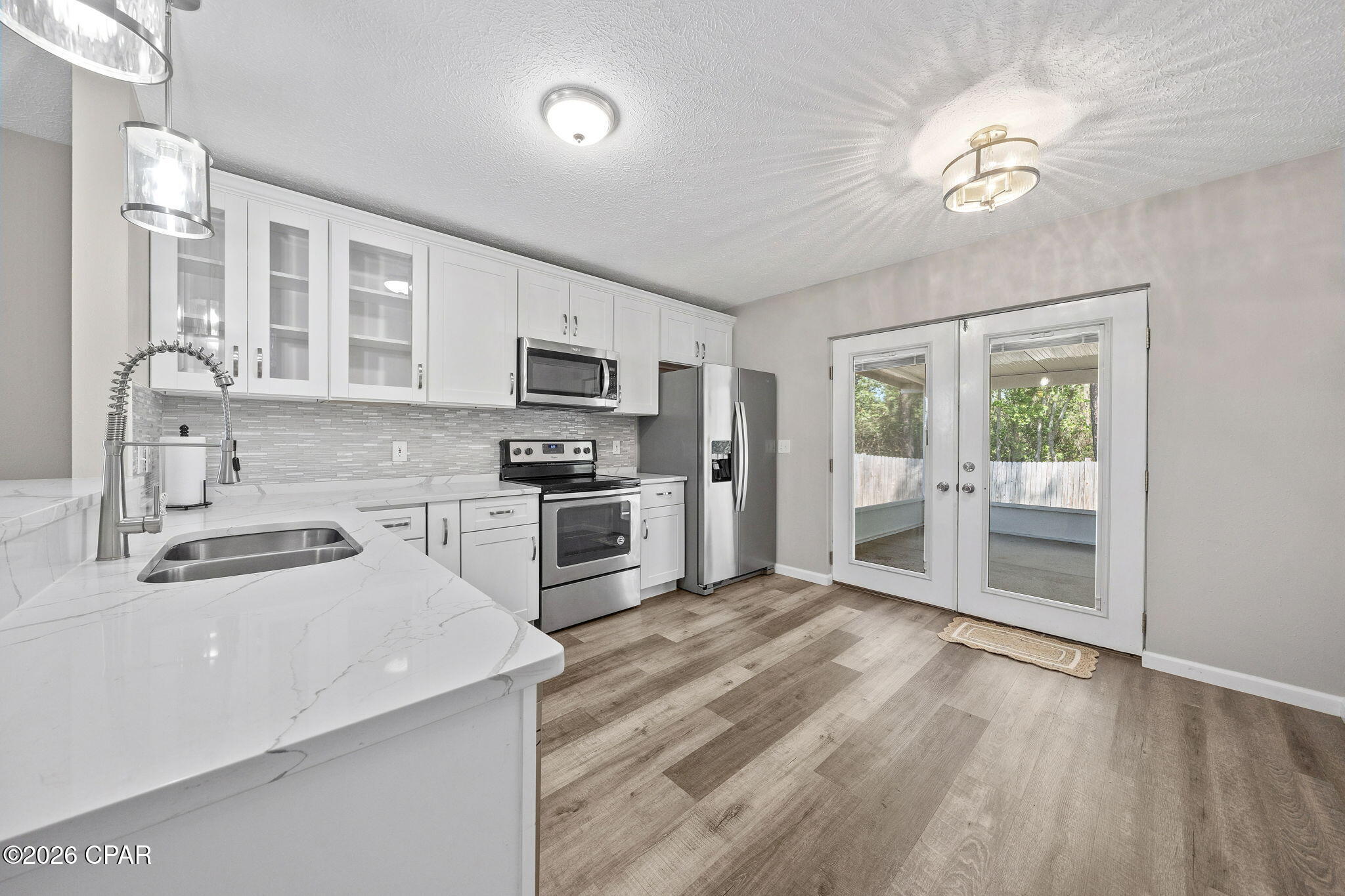 UNDER CONTRACT- SELLER MAY CONSIDER BACKUP OFFERS! This Sweetwater Village home holds abundant charm starting with the fragrant roses lining the entry path and continues into the spacious living room with vaulted ceilings.  The remodeled kitchen is nicely finished with quartz countertops, tile backsplash and SS appliances. French doors let in abundant light in the kitchen and lead out onto a screened porch that is perfect for quiet times taking in the peaceful backyard with no back neighbors! The bright master bedroom has also been updated and features vaulted ceilings with the en suite offering a double vanity with quartz countertops and new standup tile shower. The walk-in closet is conveniently located in the master bath! The split bedroom plan with two additional bedrooms rounds this home out nicely with a remodeled and bright full bath in the hallway and access to the attached garage. This home had a new roof in 2020 and fully fenced backyard. And for allergy sufferers, there's no carpet in sight! Just beautiful and easy LVP! It's a great day to take a look at this one!