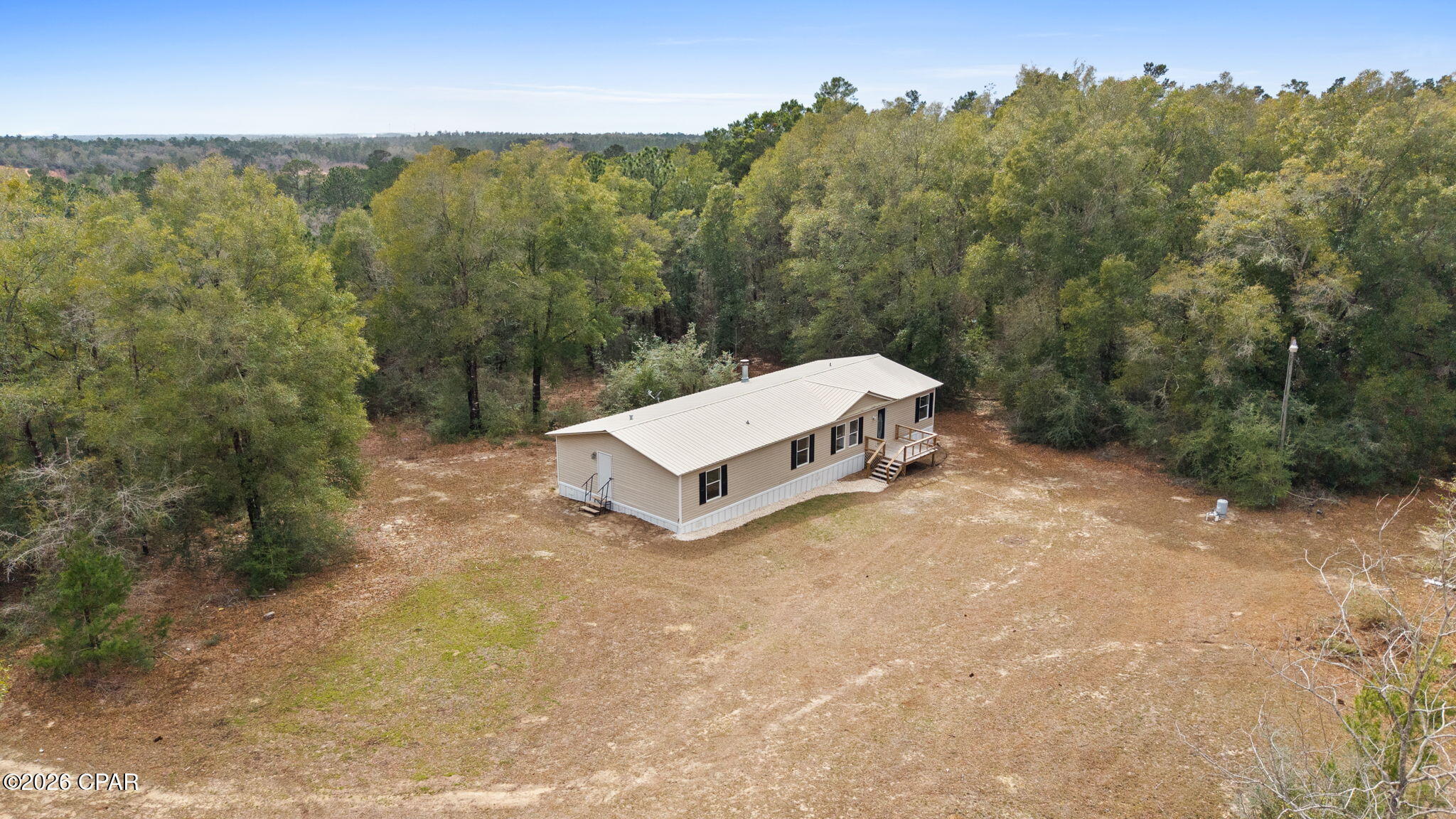 Nestled on 5 acres, serene and wooded, this fully renovated 4-bedroom, 2-bath home offers the perfect blend of modern updates and peaceful country living. Step inside to a spacious, open floorplan designed for both comfort and entertaining. The stunning kitchen features elegant quartz countertops, new stainless-steel appliance package, ample cabinetry, and generous prep space, flowing seamlessly into the main living area highlighted by a cozy fireplace--perfect for gathering on cool evenings. Luxury vinyl plank flooring runs throughout the home, offering durability and style. The oversized primary suite is a true retreat, complete with a spacious ensuite bathroom and a large walk-in closet. Three additional bedrooms provide flexibility for family, guests, or a home office. Major upgrades include a durable metal roof and a brand-new HVAC system, giving you peace of mind for years to come. Enjoy privacy, room to roam, and the beauty of nature--while still having all the modern comforts you desire. This move-in-ready property is a rare find! All located near the Sunny Hills area. Great proximity to Panama City Beach and Northwest Florida International Airport.