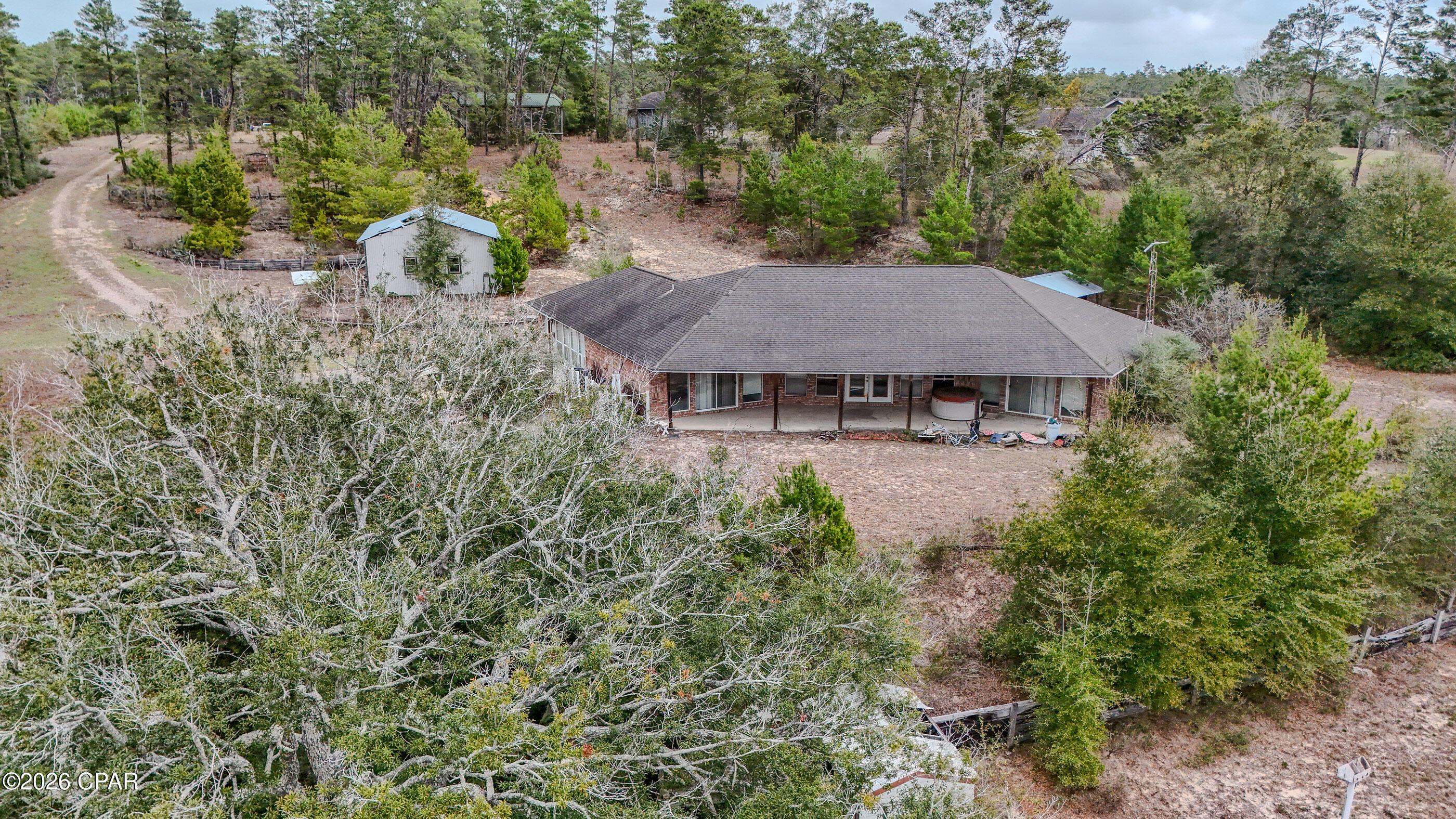 Looking for privacy and space with beautiful lakefront views? Here it is! This home is located in the Long Lake Ridge Rd Subdivision at the southern end of Washington County on Hwy 77 North of Southport and Lynn Haven. This home is ready for a new owner will need some TLC. This home has a wonderful open floor plan that puts each bedroom and full bath on each side of the house. It includes an open floor plan with real wood cabinets. The living room and bedrooms has beautiful views of the lake and includes amazing sunsets. The house has various outbuildings and pole barns that need some work. The home is sold as-is but major systems are in good shape. Plan on a new roof and new flooring. This is a beautiful property that allows horses and has a beautiful freshwater lake. Additional pictures coming soon so please check back. Easy to show.