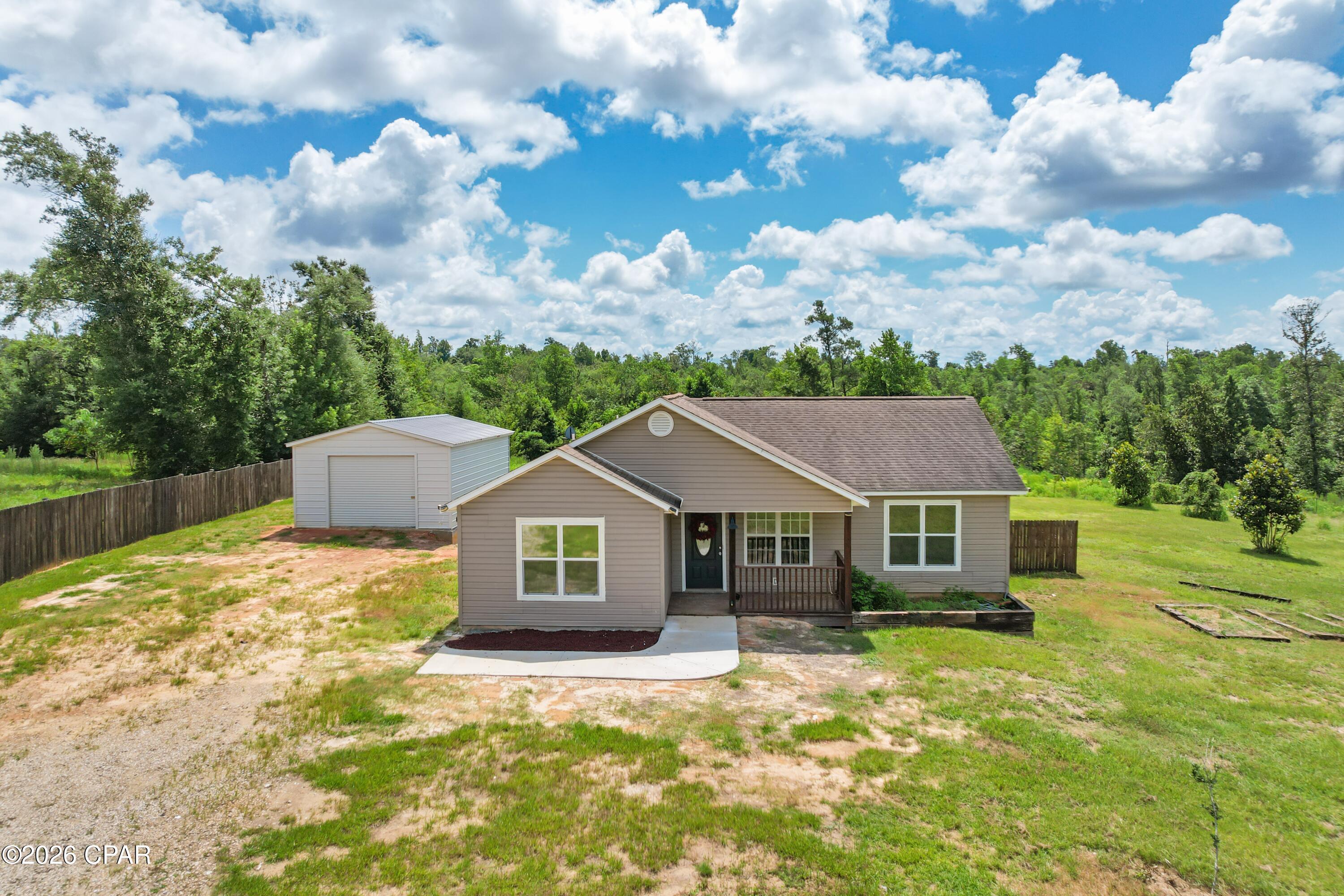 Welcome to peaceful country living at 22797 NW Watson Rd, Altha, FL! Situated on approximately 5 beautiful acres, this charming 3 bedroom, 2 bath home offers 1,120 square feet of comfortable living space and the privacy you've been searching for.

Built in 2006, the home features a welcoming covered front porch and a functional floor plan that's perfect for first-time buyers, those looking to downsize, or anyone wanting to enjoy the quiet North Florida lifestyle. Step outside to a spacious yard with plenty of room for children, pets, gardening, or simply relaxing while taking in the peaceful surroundings.

The property also includes a large detached workshop/garage, providing excellent space for vehicles, equipment, hobbies, or additional storage. The mix of cleared land and wooded acreage offers endless possibilities for recreation, homesteading, or creating your own private retreat.

Located in a quiet rural setting while still being within a reasonable drive to Altha, Blountstown, and Marianna, this property offers the perfect balance of privacy and convenience.

If you've been dreaming of owning acreage with room to spread out, this is an opportunity you won't want to miss!