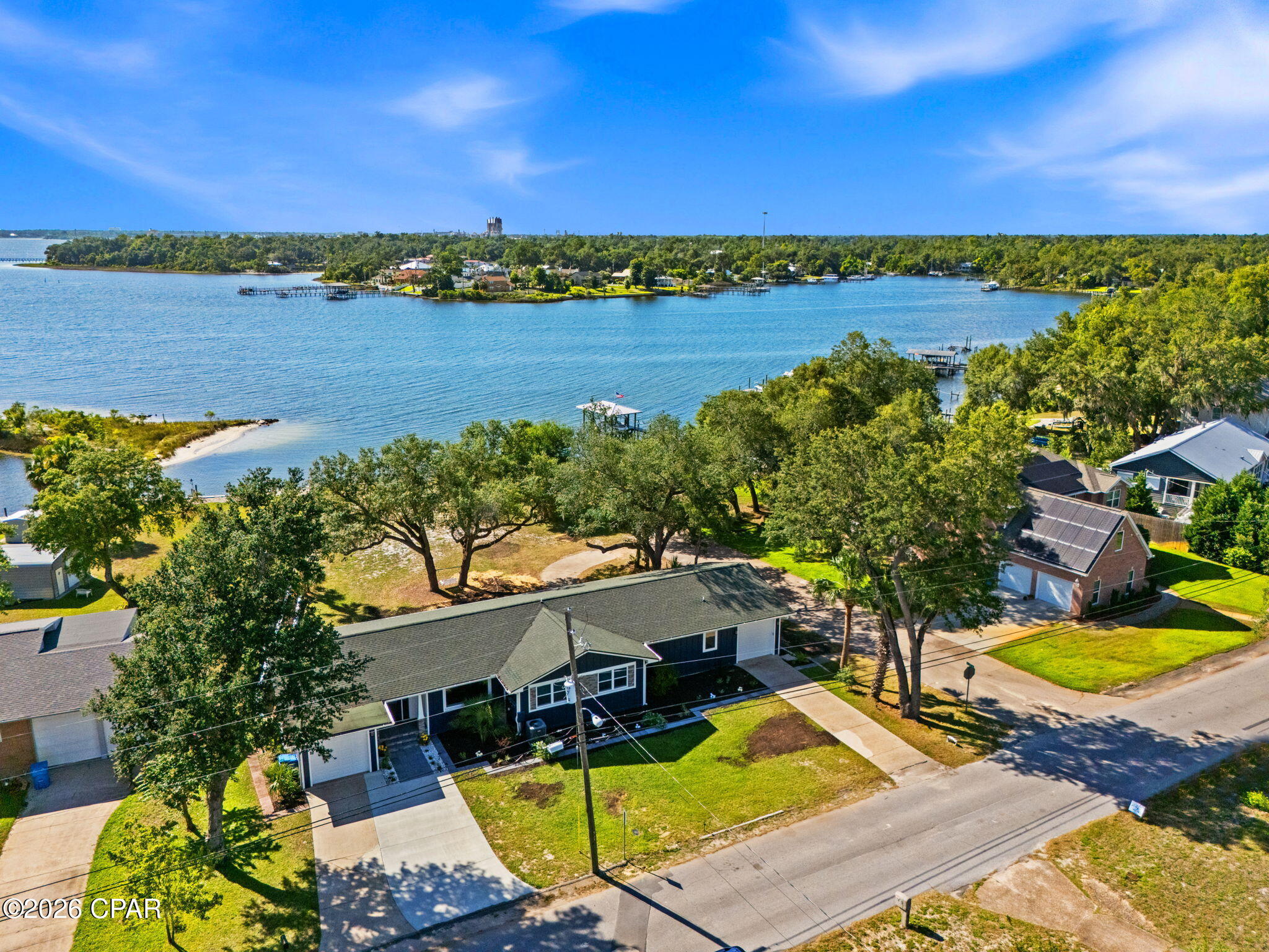 ''COMING SOON - NO SHOWINGS''
Showings can be scheduled for July 15 on.
*Stunning Deep-Water Retreat->Fully Reimagined with Gulf Access*

Tucked onto approx. 65' of water frontage with direct deep-water bay and Gulf access, 1440 Dover Road is a rare blend of craftsmanship, flexibility, and waterfront living. Originally built in 1950 and taken down to the studs in 2025, this two-story home has been transformed top to bottom -- floorplan restructured, all-new electrical and plumbing, tankless water heater, whole-house filtration system, windows, and Hardie board siding, just to name a few. Even the showers and tile floors are finished with premium epoxy grout (waterproof, stain-resistant, and mildew-proof). The roof and seawall have also been replaced.

Spanning 3,602 square feet, the home offers 4 bedrooms and 3.5 baths across two distinct living levels. The main level features a remodeled kitchen with granite countertops, stainless appliances, under-cabinet lighting, an open living and dining area, and a generous primary layout. Original red oak hardwood floors, refinished in a soft gray tint, bring timeless character with a fresh, modern feel throughout. The main level opens to a deck with a breathtaking view of the bay.

The lower level lives like its own private retreat: a second full kitchen with butcher block countertops, family room, a fourth bedroom, additional laundry room, full bath, and its own one-car garage, with both interior access and a separate ground-level entrance and driveway access. Ideal for multi-generational living, guests, or a private in-law or guest suite. There are also two attached one-car garages on the main level.

Set on just over half an acre (0.57) in an established, water-oriented neighborhood, and located in Flood Zone X (outside the special flood hazard area), a meaningful advantage for waterfront buyers. Convenient to schools, shopping, Tyndall AFB, and only 15 miles from the Naval station.

With a newer seawall and stairs leading right into the water, this property puts deep-water living within easy reach. Homes with this combination of quality, space, and true deep-water access don't come along often. This home is waiting for your dreams and memories to be made here.