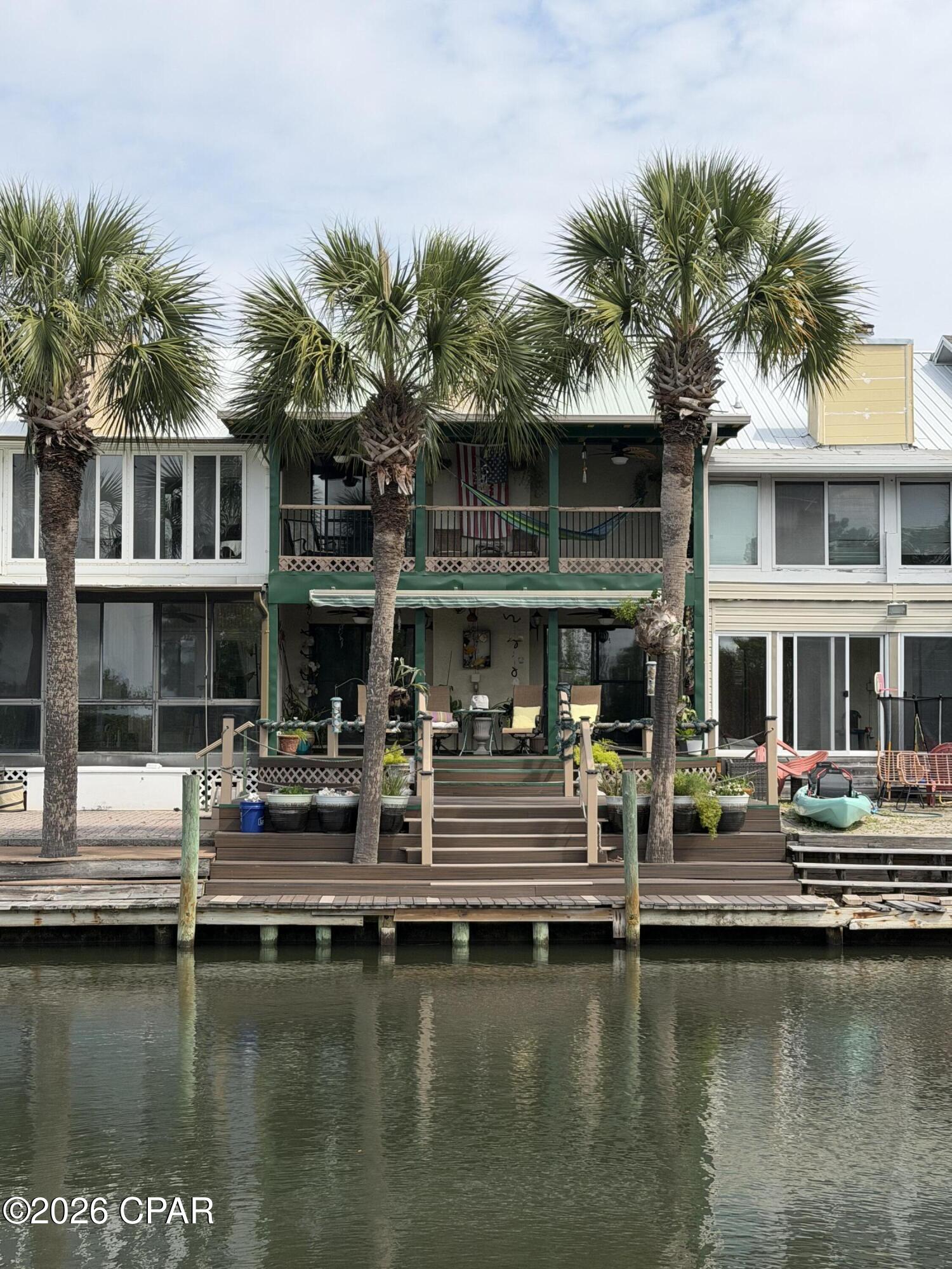 What if your backyard came with dolphin sightings, sunset views, and access to the Gulf and Shell Island  via the bay ? Enjoy waterfront living at its finest no HOA and a low maintains yard. -- where you can fish right from your own deck, launch your kayak or paddleboard from the canal, and cruise straight to the Gulf for a day at Shell Island. And yes... every now and then a dolphin -- or even a curious manta ray -- may stop by to say hello. 

The first floor features ceramic tile throughout, a spacious living and dining area, and an inviting kitchen with a modern touchless faucet for added convenience. A charming stone fireplace creates the perfect cozy atmosphere for cooler evenings. Step outside to the downstairs deck where you can relax by the water or enjoy direct canal access for a small boat or jet ski  no dock fees The decks were redone in 2022 with low-maintenance Trex Enhance decking and include an electric Sunsetter awning for shaded outdoor enjoyment.

Upstairs, you'll find 3 spacious bedrooms and 2 full baths, all with large closets and plenty of storage space. The primary suite features a private balcony with ceiling fans and beautiful water views, plus a hammock that conveys with the home -- the perfect place to unwind after a day on the water. Relax and recharge in the double jacuzzi tub while enjoying your own private retreat.

Additional features include a half bath downstairs, laundry area, attached one-car garage with Garage Shield epoxy floor systeme,with large attic for storage and  .   2024 AC unit, and a 2023 Hot Water unit with Auto booster on-demand hot water system so you'll always have hot water.  Extremely well insulated for comfort and energy efficiency Centrally located in Bay County, this well-maintained waterfront property offers the perfect blend of comfort, convenience,the laid-back coastal lifestyle you've been dreaming of. This home is more than a place to live... it's a lifestyle. Once you arrive, you may never want to leave.