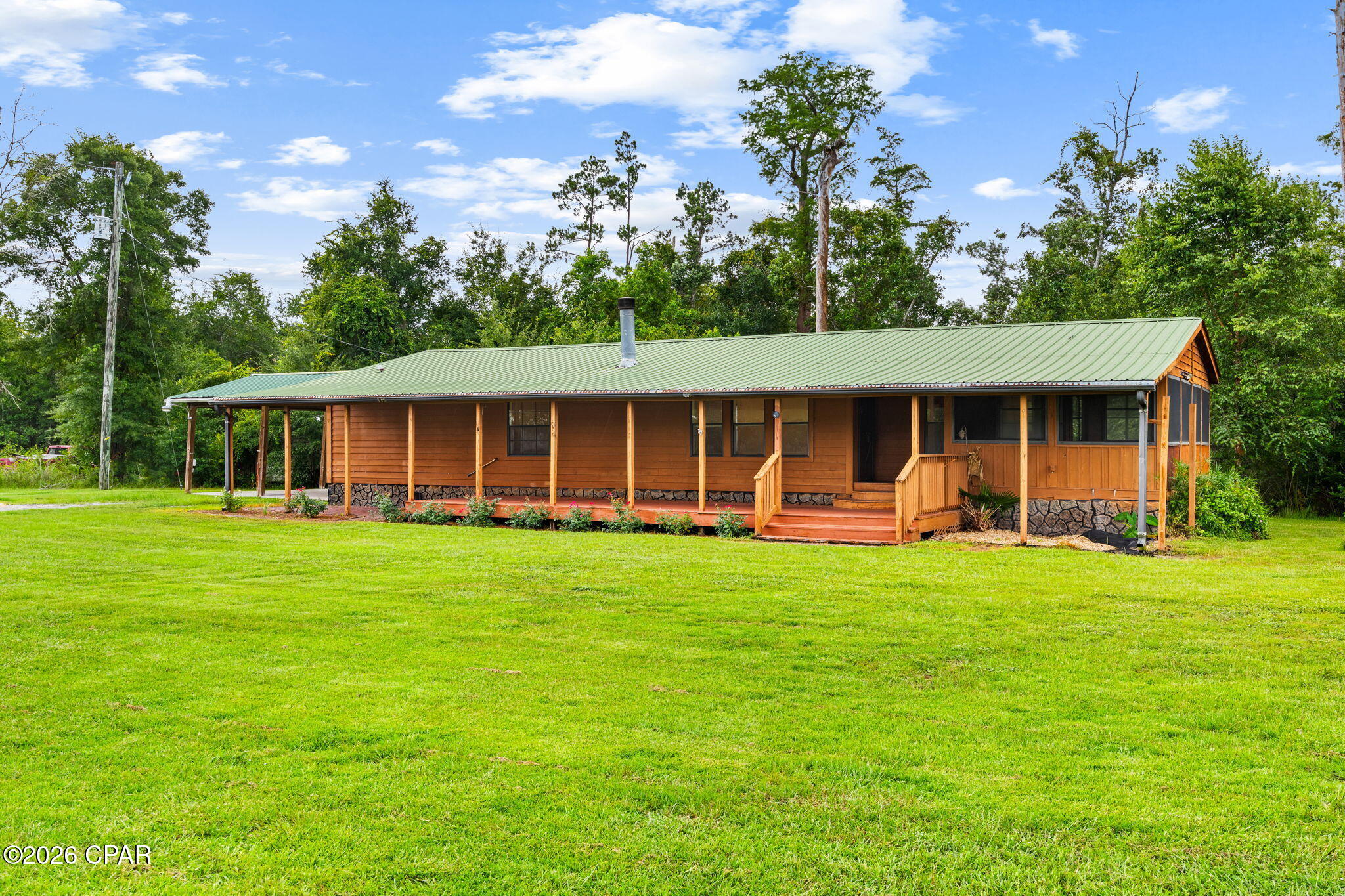 Welcome to 8306 Highway 2301 in Youngstown, where peaceful country living meets comfort and convenience. Situated on approximately 1.12 acres surrounded by mature trees, this well-maintained 2-bedroom, 2-bath home offers approximately 1,606 heated and cooled square feet with a functional, single-level layout and plenty of room to enjoy the outdoors.

Built in 1999, the home has received several updates, including luxury vinyl plank flooring throughout and interior paint completed within the last three years. The home also features a Nest thermostat, allowing you to conveniently control the HVAC system from your phone, along with an owned Culligan water treatment system.

The inviting living room features a beautiful woodburning, white stone fireplace accented by a wood mantel, creating a warm and welcoming focal point. The spacious kitchen offers stainless steel appliances, a center island, and plenty of room for everyday living and entertaining.

Just off the kitchen, a sliding glass door leads to a screened porch overlooking the property's natural surroundings; the perfect place to relax and enjoy the peaceful setting. The home also features a large covered front porch (15 x 53), providing additional outdoor living space. The spacious primary suite features two closets and a well-appointed ensuite bathroom with dual vanities, a large soaking tub, and a separate walk-in shower.

Outside, the property includes a two-car carport and a separate storage building for added convenience. With approximately 1.12 acres, mature trees, and no homeowner's association, this property offers privacy, space, and the flexibility to make it your own.

This property is also available for long term lease ($1600/month).  Please see MLS 792835