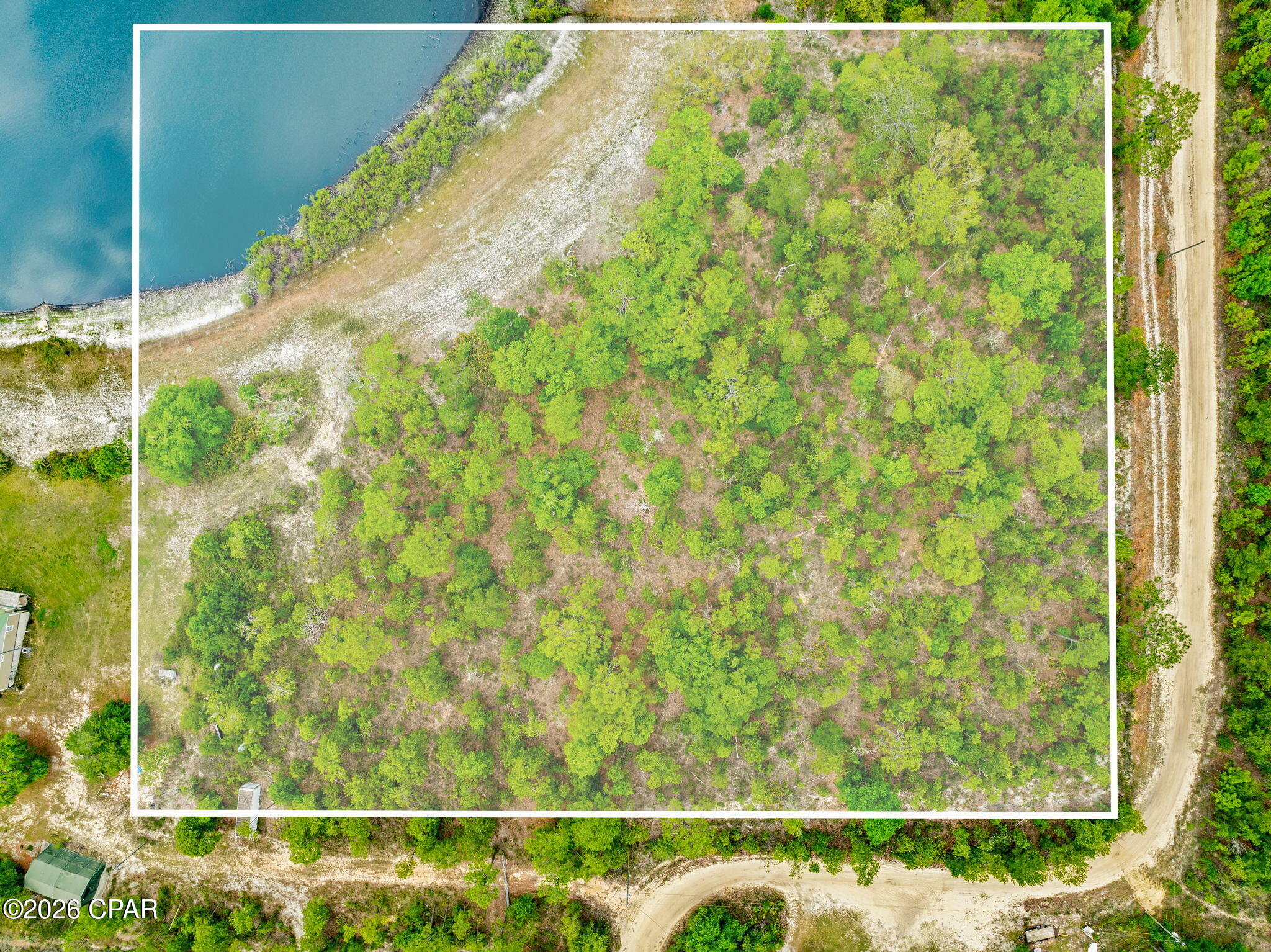 Discover the perfect blend of privacy, nature, and opportunity with this beautiful 5.56-acre homesite in Southport, Florida. Tucked away on E Woodland Road and surrounded by mature pines, native oaks, and peaceful natural scenery, this property offers the ideal setting to build your dream home, private retreat, barndominium, or weekend getaway in Florida's growing Panhandle.

The property features mostly upland terrain with well-draining Lakeland sand soils, making it favorable for future residential development. A small wetland area and scenic pond feature near the northwest portion of the property create a unique backdrop filled with natural beauty, wildlife, and tranquil views while still leaving ample usable land for a homesite and additional structures. With over 5 acres, there is room for a custom home, workshop, RV storage, gardens, trails, outdoor entertaining spaces, and more -- all while enjoying the privacy that larger acreage provides.

Imagine mornings spent drinking coffee overlooking the water, evenings around a firepit under the stars, and weekends exploring everything the Florida Panhandle lifestyle has to offer. This property gives you the peace of country living while still being conveniently located near shopping, dining, schools, and recreation in Southport and Panama City.

You're also just a short drive from Northwest Florida Beaches International Airport (ECP), making travel easy and convenient for full-time residents or second-home owners. World-famous Panama City Beach, Pier Park, boating, fishing, Gulf Coast dining, and sugar-white beaches are all within reach, allowing you to enjoy both quiet rural living and the coastal lifestyle Florida is known for.

Whether you're looking to build now or invest in land for the future, this rare acreage tract offers the space, flexibility, and natural beauty that are becoming harder to find in Bay County. Create the lifestyle you've been dreaming about -- wide open spaces, fresh air, privacy, and endless possibilities await.