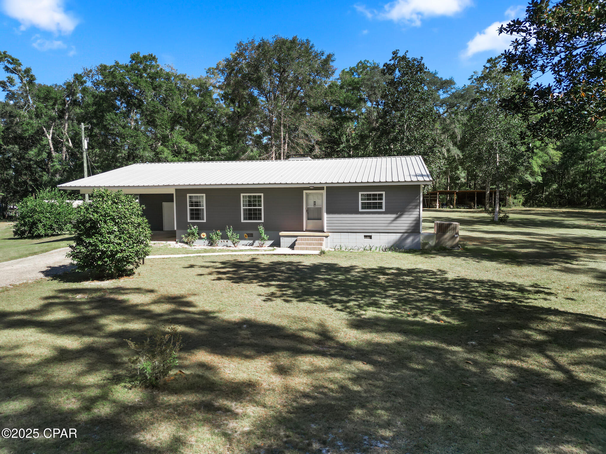 Nestled on 4.2 acres, this charming 3-bedroom, 2-bath, 1-office home offers 2,120 square feet of comfortable living space with 816 square feet of carport, screened in porch and utility room storage. This home presents a lifestyle that blends rustic charm with modern convenience.  Built in 1967 and renovated in 2008, this property is a rare find for those seeking space, privacy, and proximity to nature.

Step outside to discover a true outdoor enthusiast's paradise.  The property features multiple pole barns, perfect for equipment storage, livestock, or hobby farming.  A spacious enclosed workshop provides the ideal space for woodworking, mechanics, or creative projects.  And when it's time to unwind, the outdoor kitchen invites you to entertain.

What truly sets this property apart is its prime location.

The Ochlockonee River is just around the corner, with public access nearby, perfect for kayaking, fishing, etc.

This property borders the Talquin State Forrest, offering direct access to hundreds of acres of protected land for hiking, hunting, and wildlife watching.

Although secluded, this property is conveniently located to amenities in Tallahassee including Florida State University, shopping, I-10, etc., making it the perfect mix of convenience and private.

This home was renovated in 2008 and has been impeccably maintained since.   Updates include: The addition of a new kitchen, expansion of master bedroom, new master bathroom, and screened porch and metal roof. Home also maintains the original wood burning fireplace. 

  New a/c unit in 2018, new hot water heater in 2021.

Whether you're looking for a homestead, a weekend getaway, or a basecamp for outdoor adventures, 585 Chigger Lane delivers a rare combination of seclusion, functionality, and natural beauty- all just a short drive from downtown Tallahassee.