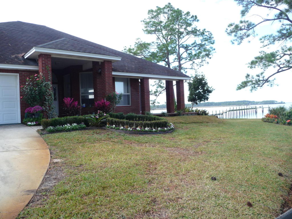 Over 2,000 sq ft of luxury living at its best in this 3 bedroom, 2 bath home with a dock and panoramic views of the water from virtually every room. No expense has been spared with upgrades such as French doors, soaring ceilings and covered porches. A handsome fireplace is centered in the Great Room with a built-in above it perfect for your TV. The Master is on the first floor with a beautiful view of the Bay and the bath has cultured marble double vanities, garden tub, separate shower and a walk-in closet. 2nd bedroom downstairs has a private patio with a shower and the third bedroom is upstairs and is a loft style. Outside is paradise with a huge custom built patio that leads to the dock. Another plus is this home faces West so the sunsets are amazing!! Deep water accessible.