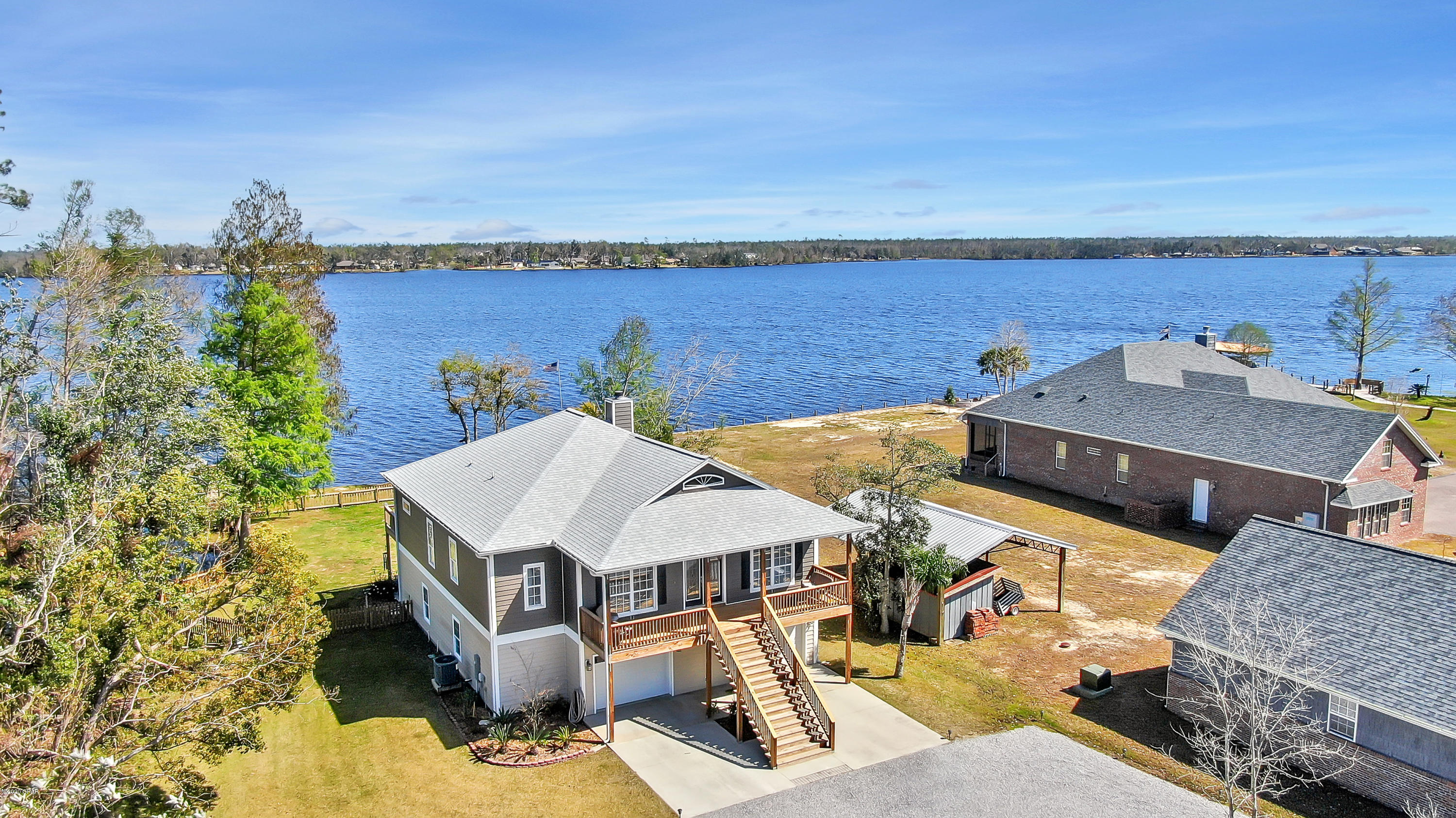 Beautiful sunrises await on this gorgeous lakefront home.  Whether you're looking for lake life, garage space or refined finishes, you can stop looking because this house has it all.  The home sits on approx. 1 acre with 100 ft of waterfront on Deer Point Lake. The first floor has a four-car oversized garage (odds are your boat will fit), plus workbenches, storage space and a heated/cooled 200 SF office that's not counted in overall sf.   Upstairs you'll find a bright and airy open concept LR/DR & Kitchen with windows and transoms galore, two sets of French doors to the screened porch with addt'l deck that runs the length of the house.  The kitchen is a cook's dream with double convection ovens, Quartz counters, 42'' solid wood cabinets, under cabinet lighting, breakfast bar, pantry and lots of storage. The split plan master suite is huge with French doors to the deck and the master bath has a luxurious walk-in shower with three showers heads/four body jets, seamless glass, a separate tub, a water closet, dual sinks and large linen closet.  There are two addt'l bedrooms, hall bath with subway tile surround and a laundry room with custom cabinetry and laundry sink. There are three garage doors, a fenced backyard with cedar picket fence and sprinkler system using lake water.  Don't wait,call your favorite Realtor to set up a showing today and ask for a list of all the upgrades this home has to offer.