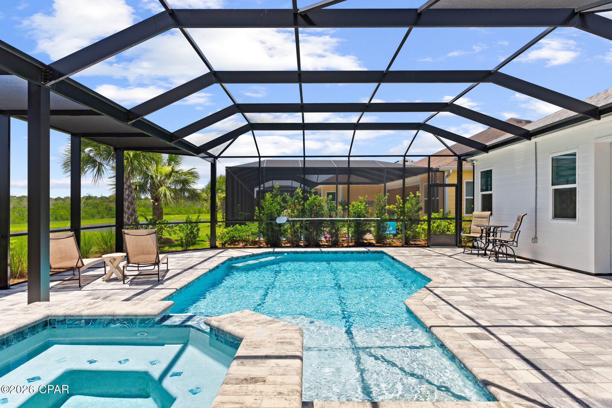 Paradise Isn't a Vacation...It's Home! Welcome to paradise in Latitude Margaritaville Watersound, the award-winning 55+ community where every day feels like a vacation. This exceptional Trinidad Bay with a heated saltwater pool/spa blends sophisticated design, luxury finishes, and effortless indoor-outdoor living. The stunning chef's kitchen is designed to impress with quartz countertops and backsplash, an oversized island, premium appliances including a gas cooktop, wall oven, microwave, and a custom walk-in pantry with spice rack. Entertaining is effortless as the kitchen flows into the dining area featuring a custom dry bar with beautiful tile, floating shelves, quartz countertops, and wine and beverage refrigerators. The inviting family room is a true showpiece, highlighted by a custom fireplace wall, handcrafted beams, illuminated floating shelves, and elegant framed grasscloth wall that showcases your favorite art piece. The private owner's suite overlooks the pool and offers blackout shades, custom closets and a spa-inspired bath with dual vanities, a zero-entry frameless shower, and upgraded floor-to-ceiling tile. Two guest suites each feature beautifully upgraded ensuite baths with tile to the ceiling, while the den with French doors provides the perfect office or flex space. Outside, your private oasis awaits. Relax in the heated saltwater pool and spa, unwind on the extended lanai overlooking peaceful ponds, and enjoy breathtaking western sunsets surrounded by a recently installed live privacy landscaping. Practical luxury continues with abundant cabinetry and a secondary refrigerator in the laundry room, while the oversized three-car garage offers built-in storage cabinets, epoxy flooring, ceiling-mounted storage, and pull-down attic access. Residents enjoy live entertainment/music, Paradise Pool, Bar & Chill restaurant, fitness center, indoor lap pool, pickleball, basketball and tennis courts, walking trails, dog park, dog spa, countless daily activities, and golf cart-friendly paths. Just minutes from shopping, dining, the upcoming public marina, the FSU/TMH medical campus. Approximately 7 miles from the sugar-white beaches of the Gulf, this home offers the perfect balance of luxury, convenience, and the carefree coastal lifestyle you've been dreaming of. Come see why this is more than a home--it's a lifestyle you'll never want to leave and where friends become family. 3 Months left of 2 year warranty!