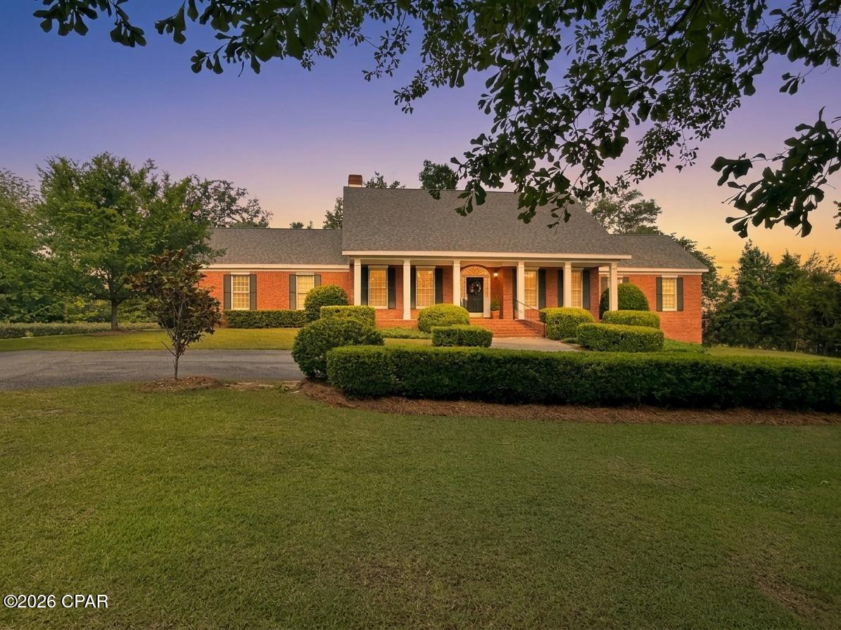 Welcome to this beautifully maintained custom home located in the heart of downtown Marianna offering 3 bedrooms, 2 bathrooms, and an abundance of flexible living space. From the moment you step inside, you'll appreciate the soaring vaulted ceilings in the main living area, classic hardwood floors, and the oversized windows that flood the home with natural light.

The front sitting room provides the perfect opportunity for a home office, formal living room, or additional flex space. Entertain with ease in the dining room featuring charming corner built-in china cabinets, or enjoy casual meals in the breakfast area open to the kitchen. The timeless kitchen design includes white cabinetry paired with elegant black granite countertops for a classic look that never goes out of style.

Just off the primary suite is an additional private sitting room ideal for a library, nursery, or personal retreat. Downstairs, the oversized 2-car garage offers exceptional added storage space rarely found in homes of this size.

This property has been meticulously cared for with numerous important updates and protective measures already in place, including a termite bond, mostly updated windows, 2018 roof, 2021 water heater, 2017 & 2011 HVAC units, new ductwork in 2025, well pump in 2025, and septic drainfield replacement in 2026. For added peace of mind, the crawlspace has been fully encapsulated and two dehumidifiers are operating in the garage to control moisture. 

The true showstopper of this property is the outdoor living space. Relax or entertain on the expansive patio and screened porch overlooking the incredibly private backyard surrounded by mature landscaping that creates a peaceful natural barrier. An additional outbuilding with finished space offers endless possibilities as a hobby house, art studio, or he/she shed. 
This is a rare opportunity to own a thoughtfully designed and exceptionally maintained home in one of Marianna's most convenient locations.