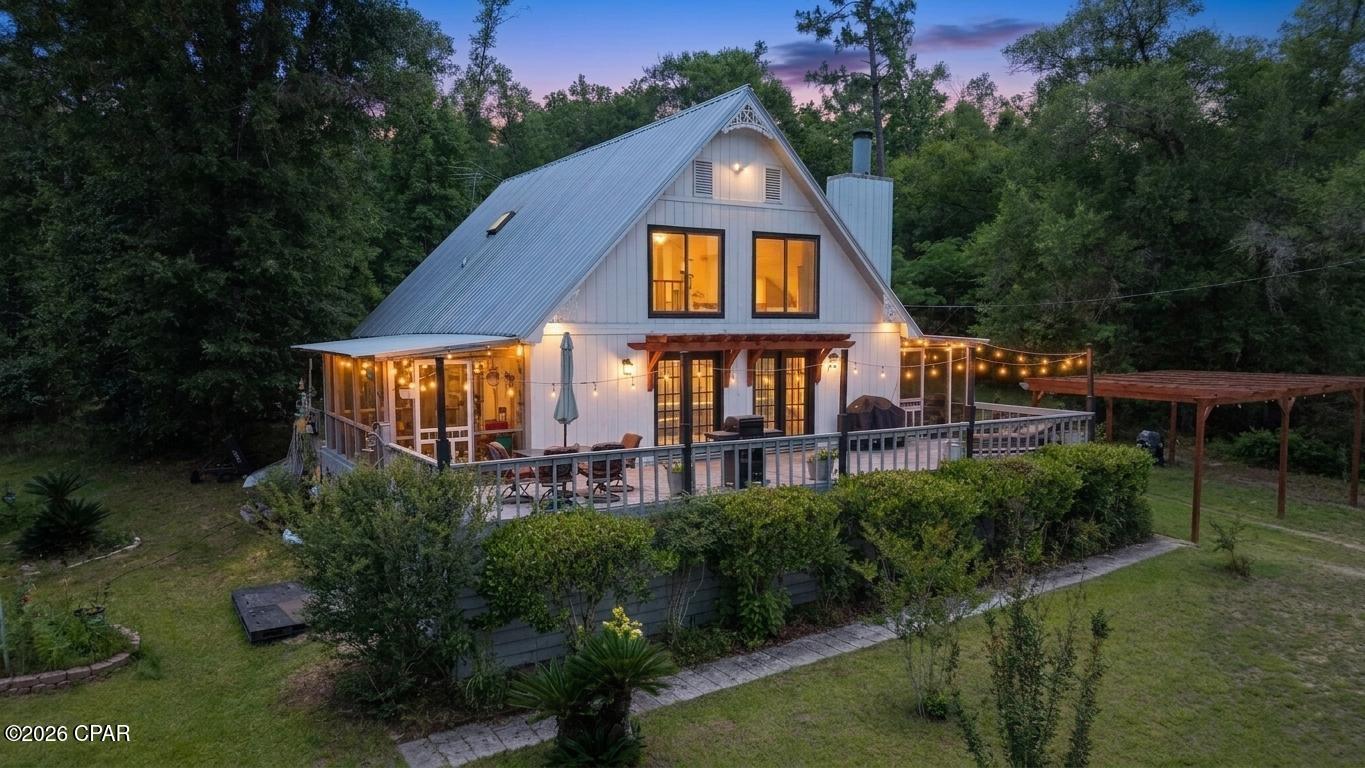 Escape to your own private retreat in Compass Lake in the Hills, where peaceful country living meets everyday convenience. Situated on 1.14 acres, this beautifully designed 3-bedroom, 2-bath home offers the perfect blend of privacy, comfort, and functionality--just minutes from Marianna and only an hour from Florida's stunning Gulf Coast beaches.

Step inside and be welcomed by soaring cathedral ceilings and an open, light-filled floor plan that creates an airy and inviting atmosphere throughout the home. The spacious living area is centered around a charming wood-burning fireplace featuring a new glass face and mantle, making it the perfect gathering spot for family and friends.

The home offers generously sized bedrooms and a versatile loft area that can serve as additional living space, a home office, hobby room, or guest retreat. Fresh interior and exterior paint provide a clean, updated look, while flooring installed in 2020 adds modern appeal.

Outdoor living is equally impressive. Enjoy relaxing or entertaining on the expansive outdoor living space, arrive via the convenient circular driveway, or park beneath the beautiful pergolas that enhance the property's charm and functionality. Pet owners will appreciate the partially fenced yard, while gardening enthusiasts will love the large fenced garden area and greenhouse.

Beneath the home, you'll find a substantial workshop offering abundant storage and workspace for projects, equipment, or recreational gear. Additional storage is available in the attic, complete with plywood flooring for easy access and organization.

Recent updates include flooring (2020), interior and exterior paint, whole-house triple water purification system, and a new well pressure tank, switch, and pump (2025).

As an added bonus, the riding lawn mower will convey with the property, making maintenance of your beautiful acreage even easier.

If you've been searching for a home that offers privacy, space, modern updates, and convenient access to town amenities and Florida's world-famous beaches, this exceptional property is ready to welcome you home. Access to Compass Lake amenities and HOA is optional.