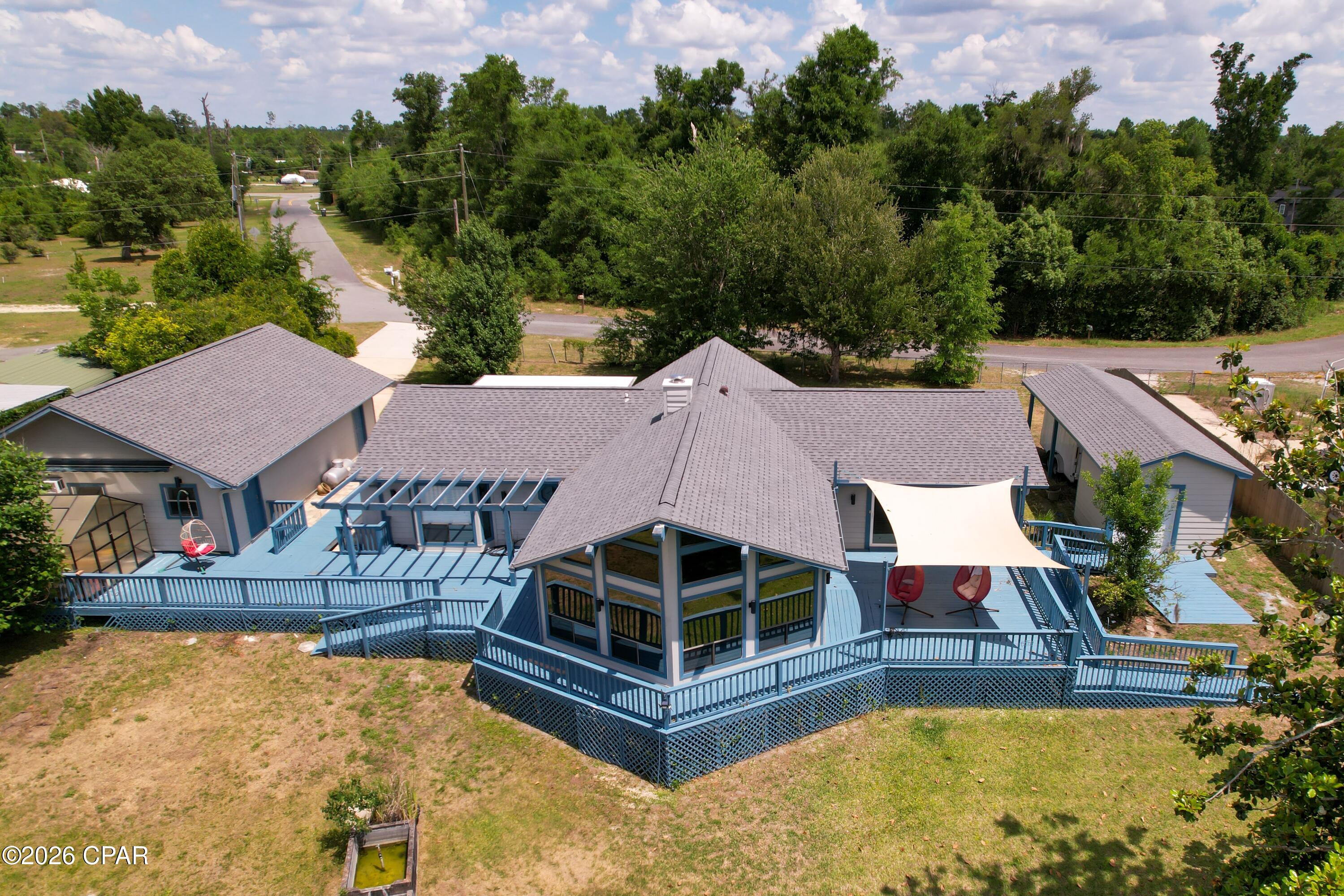 Situated high above the pristine upper reaches of Deerpoint Lake, this custom-designed home offers panoramic water views that must be seen to be believed. Facing due west to capture breathtaking Florida sunsets, the home boasts a half-mile unobstructed view across the water to state-protected land that will never be developed--ensuring your privacy and wild, natural surroundings forever.

Designed to maximize its incredible setting, the home features a striking prow-front design with soaring vaulted ceilings and floor-to-ceiling windows, offering a dramatic 270-degree view of the lake, majestic cedars, and cypress trees. Watch ospreys and eagles fish from the comfort of the massive great room, anchored by a cozy wood-burning fireplace. Step outside onto over 1,000 square feet of expansive decking--perfect for entertaining or peaceful morning coffee. The property slopes gently down to the water's edge, complete with a private dock and a covered boathouse ready for your fishing or pontoon boat.

This home offers a wide array of premium outbuildings, all architecturally matched to the main home for a clean, cohesive look. You have an oversized 24x24 two-car garage with an attached climate-controlled 12x24 workshop, fully outfitted with counters and cabinetry.  There is a separate, covered high-clearance port perfect for an RV or large boat, while a dedicated utility building with a roll-up garage door and ramp easily accommodates a riding mower or golf cart. Plant lovers will also rejoice, as the property even features its own private greenhouse.

Inside, the massive master suite serves as a private sanctuary, featuring a generous walk-in closet, double vanities, a jacuzzi soaking tub, and private sliding glass door access to a shaded deck. The spacious kitchen is perfect for hosting, equipped with durable solid-surface countertops and a brand-new stainless steel refrigerator.

Current wind mitigation and 4 point inspection reports are on file.  New interior and exterior paint 2026, New roof 2024, New water heater 2021, New HVAC 2015, New septic 2013.