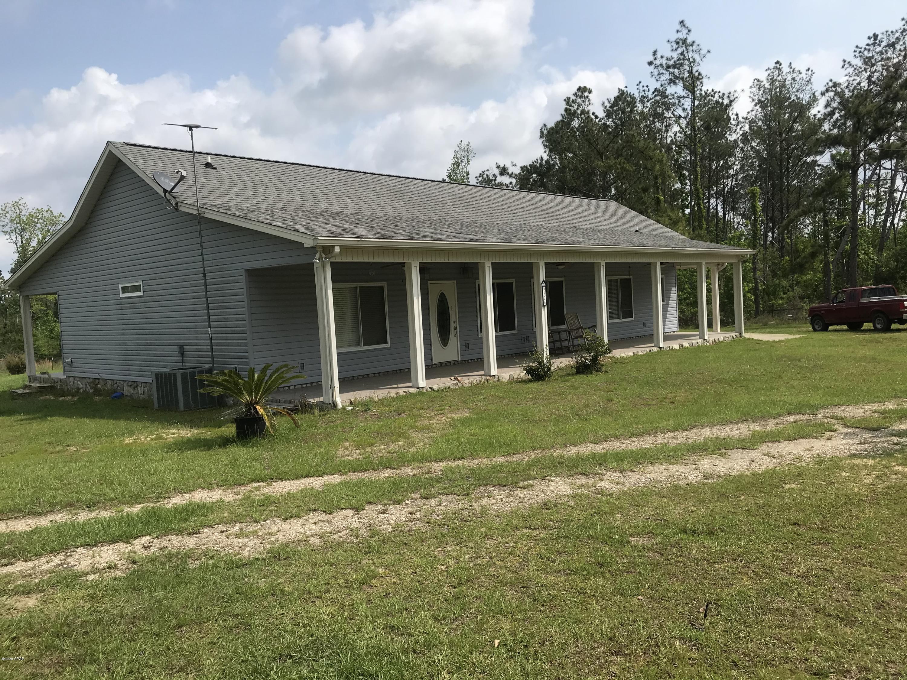 PRIVACY!  You will love this quiet country retreat on 10 acres with a pond.  This very nice 3 bedroom 2 bath split plan has 9' ceilings, crown molding, custom cabinetry and ceramic tile throughout the home.  Large walk-in double head shower in the master bath.  All interior doors are pocket doors.  Porches on the front and back of the home extend the length of the home for enjoying your country living.  There is a drive through carport attached to the home.  Includes a very nice 60x32 workshop with several rooms inside and two pull down garage doors.  Great family home!