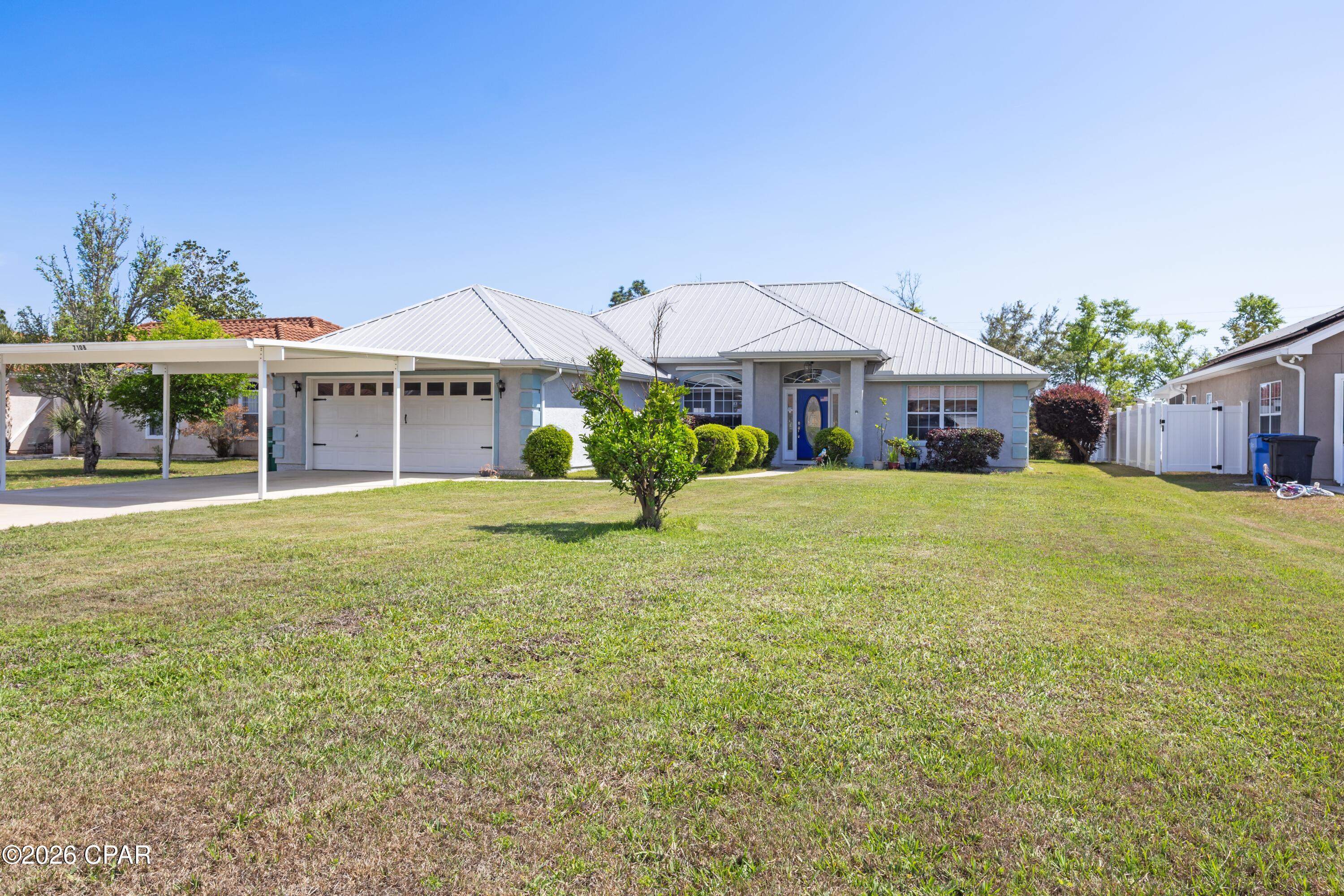 Seller offering a $3,000 credit toward closing costs, prepays, or rate buy down with acceptable offer. Beautiful, well-maintained 3BR/2BA home with no HOA, situated on a spacious .27-acre lot and offering 1,801 sq ft of living space.  Built in 2005, this home features a long list of upgrades and thoughtful touches throughout, including a 2019 hurricane-rated 26-gauge metal roof, 5'' thick concrete driveway with extended parking (poured in 2020), a hurricane rated insulated carport (2020) and 12' x 12' hurricane-rated storage building with concrete floor.
Inside, you'll find solid wood cabinetry, granite countertops, and stainless-steel appliances (stove 2024, microwave 2021, dishwasher 2020), along with 19'' porcelain tile throughout the main living areas and bamboo flooring in the bedrooms. The spacious main suite offers dual vanities, his-and-her walk-in closets, a floor-to-ceiling tiled shower with dual wall-mounted heads and ceiling-mounted rainfall fixture, plus a separate jetted tub. Additional highlights include a large laundry room with a flex space that could be utilized as an office nook or additional storage, ceiling fans throughout, custom blinds, LED lighting, and an energy-efficient Carrier HVAC system. Exterior features include a screened-in tiled back porch, covered grill area, storage building, hurricane shutters, irrigation system with well pump, and security motion lights for driveway and backyard.  This home is conveniently located with easy access to Tyndall Air Force Base, Naval Support Activity Panama City, shopping, dining, public boat ramp, and the Gulf Coast beaches. All measurements are approximate; buyer to verify if important.

Additional Notes:  
1. The roof is 26-gauge steel (25% thicker than standard residential 29-gauge steel).  Sherwin Williams finishes with high Solar Reflective Index (SRI) value, resulting in cooler attic temperatures versus other types of roofs, thus energy savings summer electricity bill.
2. New exterior Sherwin-Williams Premier Loxon XP paint (2025)
3. Radiant barrier insulation and foam insulation in the south and west facing walls.
4. Quiet belt-driven garage door opener with premium nylon rollers
5. Backyard features mature trees/bushes, arbor with grape vines, and a blueberry plant. Backyard access via easement behind home. Fenced on two sides from adjoining neighbors' fences.  Trees/bushes and shed provide privacy at back of property, but if desired can easily be enclosed. 
6. Transferable Termite bond with Ensec