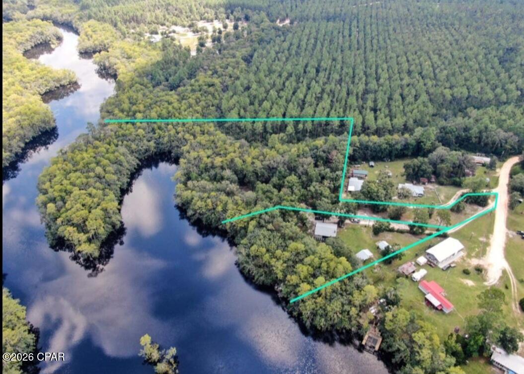 Rare East River waterfront retreat and investment opportunity offering approximately 6.76 total acres across two parcels, with deepwater access, two concrete boat launches, and a dock creating an ideal setup for boating, fishing, and waterfront living. Surrounded by the natural beauty of Pine Log Forest, this property delivers privacy, river access, outdoor recreation, and multiple income or expansion possibilities.

The primary parcel includes approximately 1.19 acres with 294 feet of East River frontage. The main residence is elevated on pilings and features 3 bedrooms, 2 bathrooms, approximately 1,040 square feet, a 1-car garage, and a 30' x 8' porch overlooking the East River and wooded surroundings. The home has been updated with luxury vinyl plank flooring, modern lighting, stainless steel appliances, kitchen and bathroom improvements, an open living and dining layout, and a fireplace. The lower level of the primary residence is partially finished and offers approximately 1,280 square feet with concrete flooring, exterior walls, plumbing, electrical, and storm windows and doors in progress, creating potential for additional living space or duplex-style use.

A separate renovated 1 bedroom, 1 bathroom guest cottage offers flexibility for guests, rental income, or multi-generational living. There is also a 16' x 14' backyard shed that may offer additional storage or future use potential.

The adjacent 5.57 acre parcel includes approximately 1,605 feet of river frontage and features a concrete deepwater cove boat launch. The parcel has been partially cleared with driveway access, and power, septic, and artesian well water are reported to be available on site. This additional acreage creates a strong opportunity for a private retreat, rental compound, tiny home concept, or build-to-suit vision, subject to zoning, permitting, and buyer verification.

The property also includes two concrete pad boat launches, a riverside dock landing area, and pier walkway access for convenient access to the river. The East River connects toward the Choctawhatchee River, Choctawhatchee Bay, and the Gulf.

Reported improvements include a 2019 architectural roof, 2020 HVAC system, 2020 50-gallon water heater, 2019 storm windows and sliding glass doors, 2022 septic leach field upgrade, 2020 LVP flooring, kitchen and bathroom updates, stainless steel appliances, and modern lighting. The detached guest cottage was built in 2011, and the backyard shed was built in 2012.

Conveniently located approximately 21 miles from the Gulf and approximately 15 miles from Northwest Florida Beaches International Airport. Seller financing may be available to qualified investment buyers.