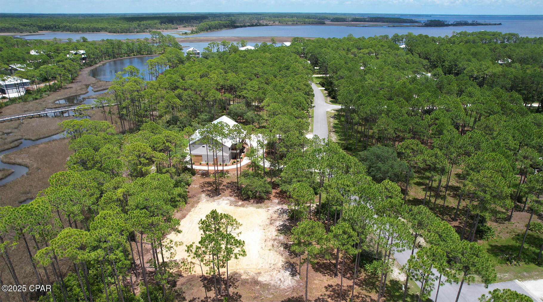 Lot is cleared and plans are approved on this 4-bedroom (or 3-bedroom with an office) 3- full bath home that will include an elevator. Stillwater Homes Coastal Construction will be building this beautiful home in the gated, waterfront community of RiverCamps on Crooked Creek. Buyer may be able to make personal selections dependent on stage of construction and builders' allowances. Notable features of this home will be the side-by-side Thermador fridge/freezer, Thermador gas top stove with electric oven. A walk-in pantry. Quartz countertops. The open floor plan will be highlighted by the soaring 10'x10' cupola. A screened in porch that will run the length of the back of the home (60 feet long and 647 sq ft!). An elevator from the ground floor to the main floor's foyer for ease of access. 10 ft ceilings throughout. Builder even has a model home available to be viewed to showcase finished plan. Beneath the home you will have a 2-car garage with 738 sq ft plus two large storage areas, one is 986 sq ft and the other is 371 sq ft, that would make an amazing shop and/or storage for all of your toys. Home will be situated on a .8-acre lot and backs to the salt marshes with a creek view. The newly completed pool and pavilion is less than 1/2 mile away.
RiverCamps is a gated, outdoor enthusiasts dream. 1500 acres with 1000 acres committed to conservation and the remaining 500 acres will have less than 450 homesites. This golf cart friendly community has over 7 miles of connected trails and boardwalks, is bordered by Crooked Creek, West Bay and the Intracoastal Waterway. Owners enjoy onsite dry boat storage, a community boat ramp that has direct access to West Bay and the Gulf with a short 30-minute boat ride. Day use boat slips, a 600 ft pier, campsite on the creek with adult tent and kid tent and a bath house. There is also a basketball court and 2 pickleball courts. 
RiverCamps is conveniently located 10 minutes from the NW Florida Beaches International Airport, 10 miles from Pier Park and the famous white sandy beaches, 5 miles to the new hospital/medical plaza and 2 miles from the recently announced 500,000 sq ft retail development that will include Publix Grocery.