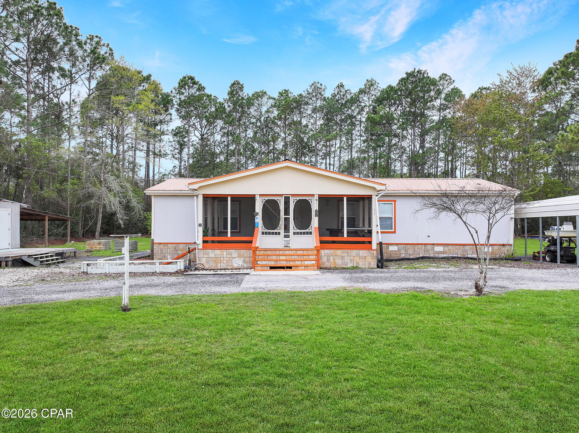 Enjoy the freedom of country living on this 1-acre property with no restrictions, located just minutes from Apalachicola River boat ramp and easy bay/gulf access. This 3-bedroom, 2-bath mobile home has been nicely renovated and well cared for, waiting for you to add your touch. Relax on the screened-in front porch, perfect for enjoying the outdoors year-round. The property offers plenty of space for all your toys with room for boats, RVs, and additional parking. A standout feature is the charming she-shed complete with electricity, water, and air conditioning, ideal for a hobby space, workshop, or private retreat. You'll also find multiple storage buildings providing ample room for tools, equipment, and outdoor gear. And covered parking for your boat. Room for gardening and livestock, including an orange tree, gravevine and chicken coops. Located just minutes from charming downtown Apalachicola shopping, dining, parks and marina. With space, flexibility, and convenient access to the water and hot spots like St. George Island, this property is perfect for those looking to enjoy coastal living with room to spread out. 3D tour available