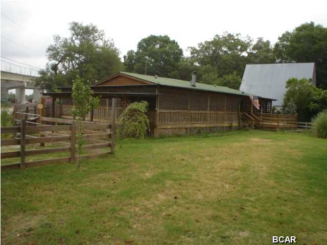 Great home just min from PCB!  Home is on 1 acre and is just around the corner from a public boat ramp, fishing pier and of course BoonDocks!

Home has a wrap around porch and deck, a beautiful yard, lots of privacy.  Home is located on small canal leading to Bay.  Home is also zoned Commercial, Business interests please inquire.  Interior has cedar walls, a fireplace, a nice open kitchen/floorplan. Master has soaking tub, split floorplan.  This unit always rents fast!  Call today.