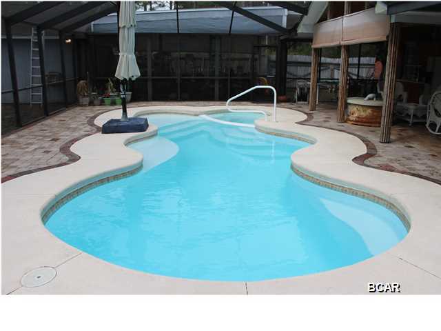 Don't miss out on your opportunity to own this BEAUTIFUL entertainers dream home; complete with 4 bedrooms, 2 baths, and a GORGEOUS screened and heated saltwater pool with hot tub located close to Tyndall AFB. This home features split bedrooms with an outdoor entertaining area you won't believe; complete with outdoor kitchen with cabinets, sink, refrigerator, wired for surround sound, gas fire pit, and a TV wall mount ready for you to entertain! There is custom tiled flooring in the entryway. The living room features a wood burning fireplace, vaulted ceiling, and a slider door that leads to the pool. The screen pool enclosure is 40X45 and the covered patio is 16X45. There is a spacious eat-in kitchen and a formal dining room. The master bath has a whirlpool tub, custom tile flooring,