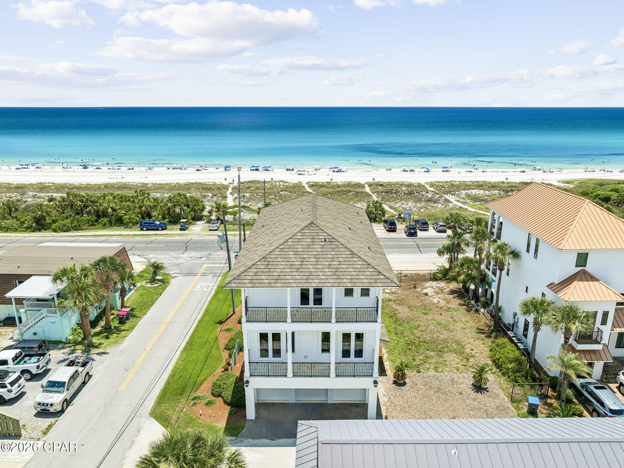 Elevate your coastal lifestyle in this one-of-a-kind, 4,000+ square-foot beach home, ideally positioned directly across from the protected dunes of Laguna Beach. A rare offering in one of the area's most desirable locations, this exceptional property offers unobstructed Gulf views and convenient beach access, creating the perfect setting for unforgettable family gatherings and everyday coastal living. Designed for effortless entertaining, the home features a stunning exposed brick kitchen that flows seamlessly into an expansive living area with soaring 12-foot reclaimed wood ceilings, blending warmth, character, and sophisticated coastal style. Enjoy breathtaking Gulf views from multiple levels, including the private top-floor primary suite, where spectacular sunrises and sunsets become part of your daily routine. The home offers five luxurious bedroom suites, each thoughtfully appointed with a king-size bed with en suites, providing comfort and privacy for family and guests alike. Step outside to your private second-floor heated infinity pool overlooking the Gulf, or take advantage of the commercial elevator providing convenient access to every level. Additional highlights include a spacious three-car garage and the convenience of being offered fully furnished and turnkey, ready for immediate enjoyment or investment. Blending timeless coastal elegance with exceptional amenities, this extraordinary retreat offers luxury living just steps from the sugar-white sands and emerald waters of the Gulf.