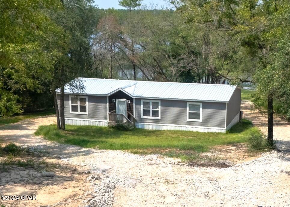 BEAUTIFUL 2023 HOME ON THE LAKE!  NEARLY AN ACRE! The interior features 3 bedrooms, 2 baths, an open floor plan with split bedrooms (great for entertaining), ample natural light, crown molding, LVP flooring, and a sizable laundry room / butler's pantry with added storage and sink.  The living room has built-in bookshelves and a large electric fireplace.  The kitchen boasts ample counter and cabinet space, stainless steel appliances, an island with breakfast bar and even more pantry space! The master bedroom has a walk-in closet and can accommodate King Size furniture.  The adjoining master bath has a soaking tub, double vanity, and separate shower. The other 2 bedrooms have walk-in closets and share a hall bath with shower/tub combo.  The exterior features a metal roof, an easy maintenance exterior, and a natural beach to the lake.  Canoe, boat, swim, and fish from your backyard. Call today for a private preview.  Measurements approximate.