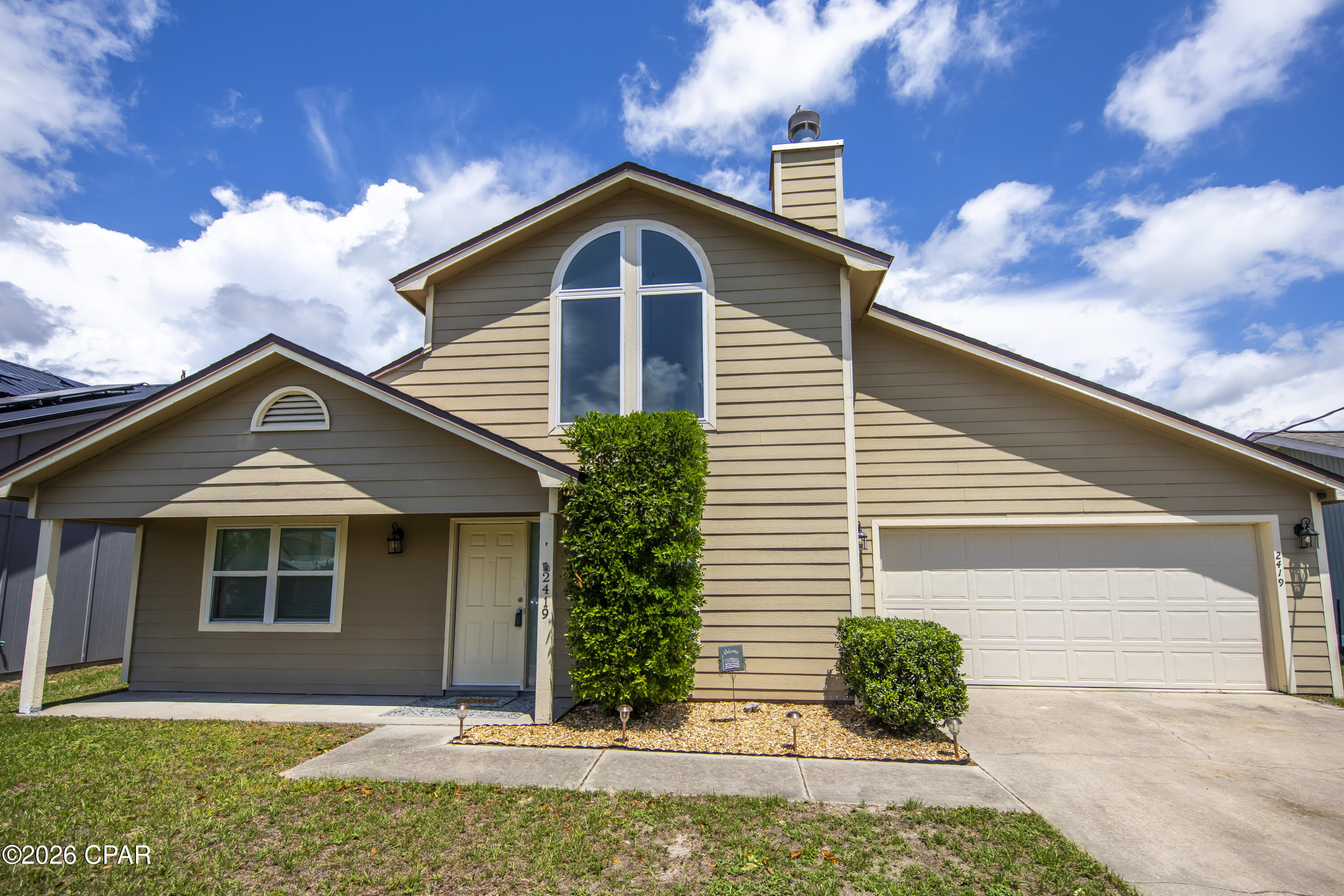 Welcome to 2419 Kimberly Drive in the desirable Belaire Subdivision of Lynn Haven!  Quietly tucked away toward the back of the neighborhood, this beautifully maintained 3-bedroom, 2- bath home offers comfort, space, and convenience in one of Bay County's most sought-after areas. Step inside to an inviting open living area featuring soaring two-story vaulted ceilings, a cozy real wood fireplace, and a seamless flow into the dining area and kitchen - perfect for everyday living and entertaining  alike. Just off the kitchen, you'll find a versatile bonus room currently being used as  an office, ideal for working from home, hobbies, or additional flex space. The downstairs  level offers two spacious bedrooms and a full bath, while the large upstairs Master Suite provides a private retreat complete with its own full bath and walk-in closet. Enjoy outdoor living in the fenced backyard featuring a large 17x19 deck perfect for grilling, relaxing, or gathering with friends and family. Two storage sheds provide plenty of additional storage space, and the home also includes a two-car garage along with a generous laundry/storage area. Conveniently located near the USPS, highly sought-after schools, Walmart Supercenter, Publix Super Market, and numerous popular restaurants, this home places you close to everything while still offering a peaceful neighborhood setting. Lynn Haven continues to be one of Bay County's most desirable communities thanks to it's charming coastal atmosphere, location near North Bay, and it's many community concerts, festivals, and events held throughout the year at City Hall. This home is exceptionally clean, and completely move-in ready for its next owners to enjoy!